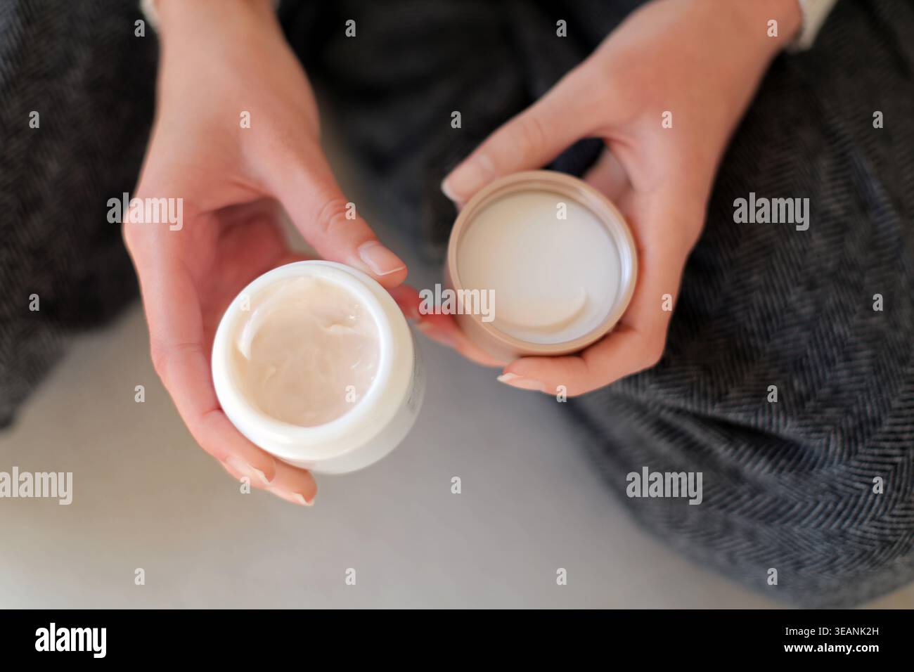 Ouvrez le pot de crème hydratante dans les mains. Gros plan des mains tenant un pot ouvert de crème pour le visage, montrant la routine de soin de la peau, produit hydratant, et personnel Banque D'Images