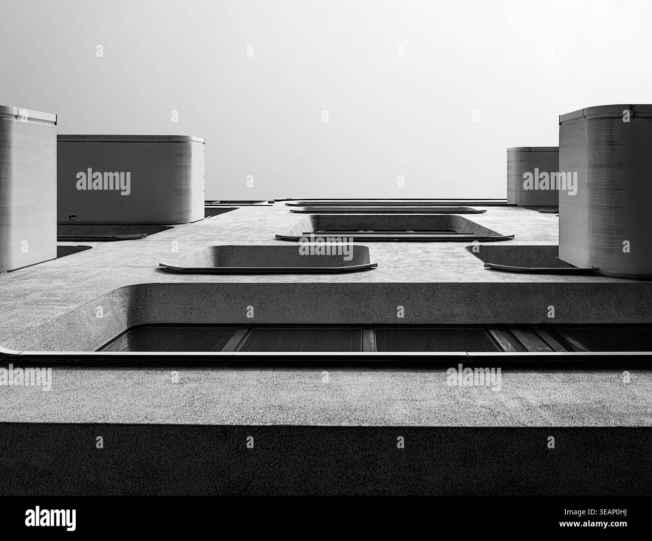 Image architecturale en noir et blanc de balcons en béton modernes s'élevant dans un rythme vertical propre, créant un motif géométrique fort idéal pour desi Banque D'Images