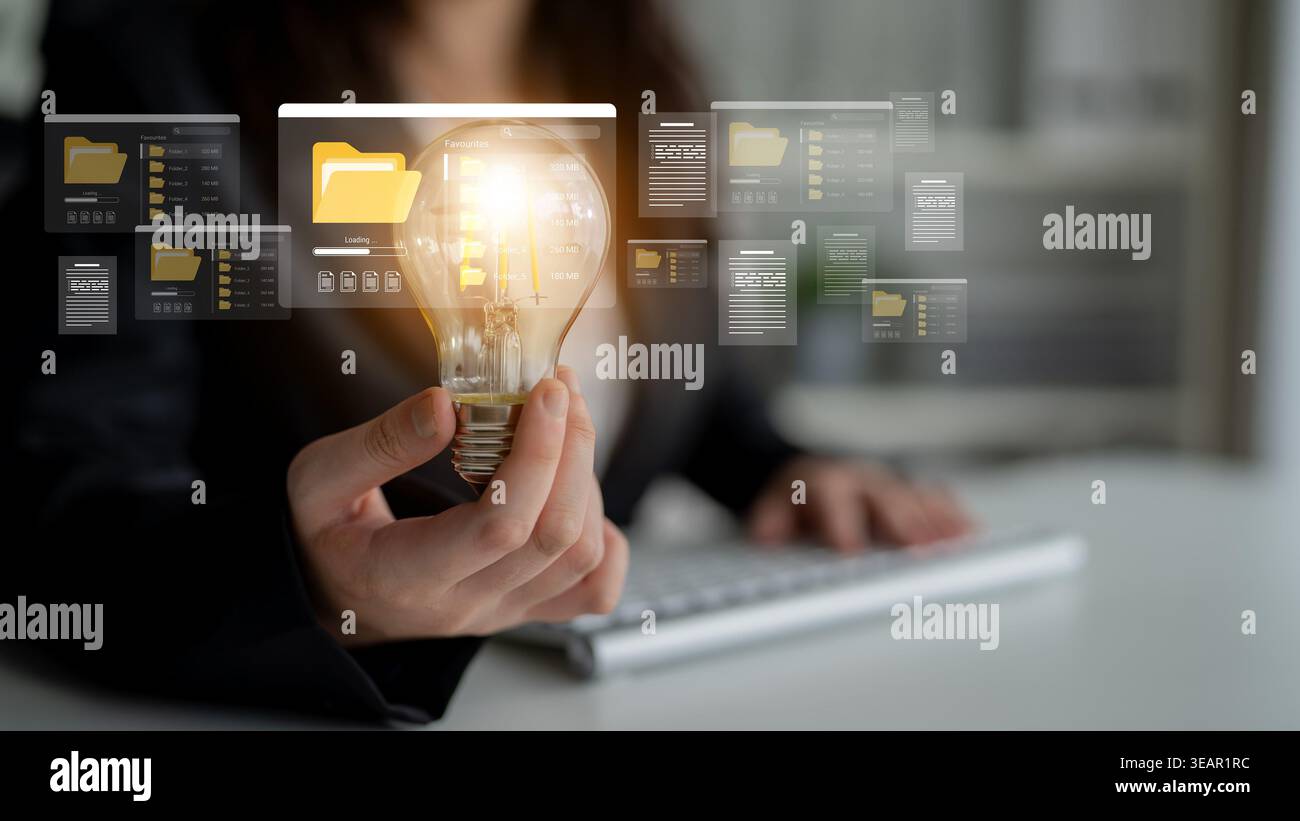 Un professionnel des affaires tient une ampoule symbolisant des idées innovantes au milieu de documents numériques et de dossiers dans un cadre de bureau, soulignant Banque D'Images