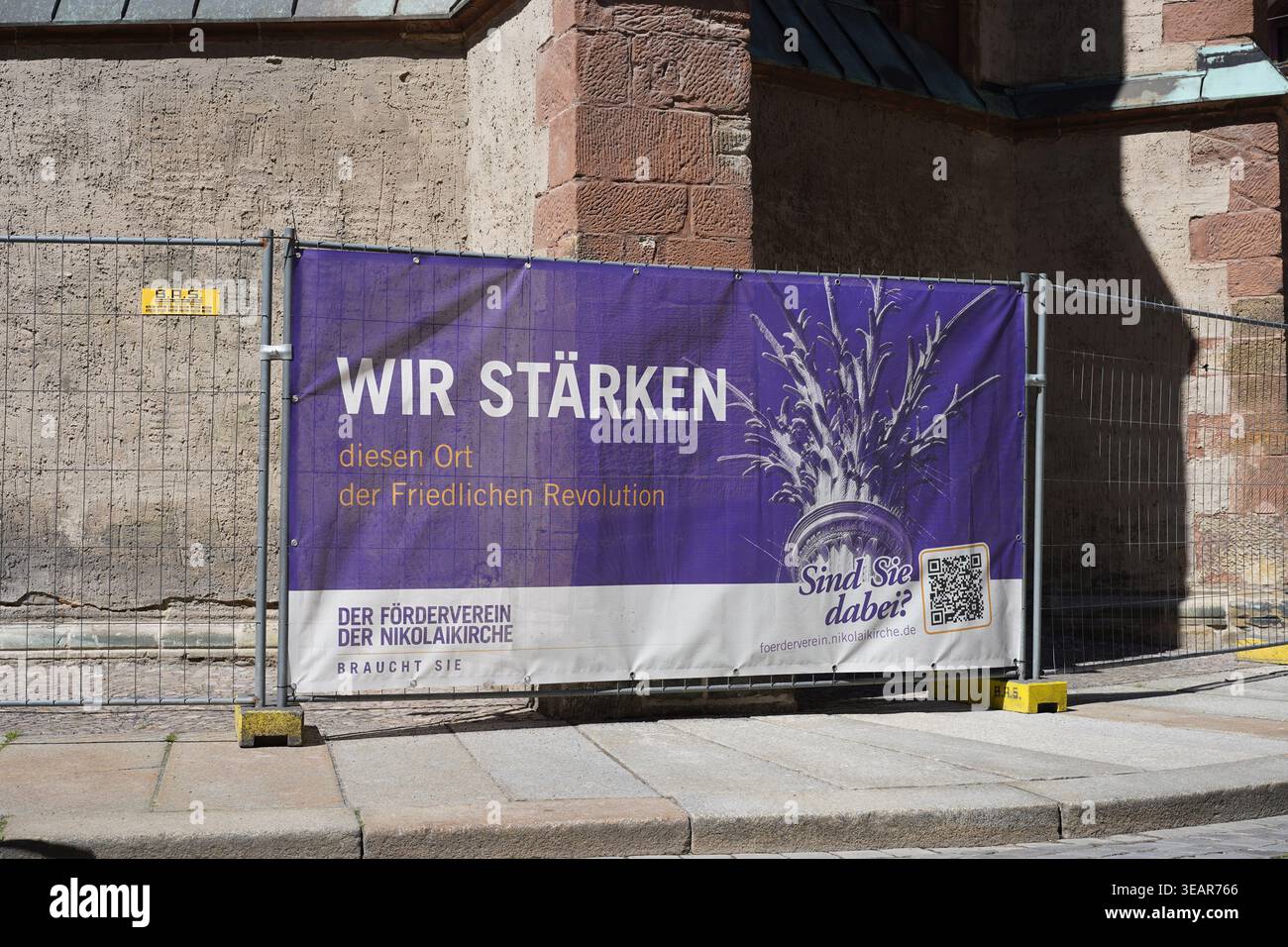 Leipzig, Allemagne - 22 avril 2026 : bannière violette de collecte de fonds pour l'église Saint Nicolas sur une clôture de construction, mentionnant la révolution de 1989. Banque D'Images