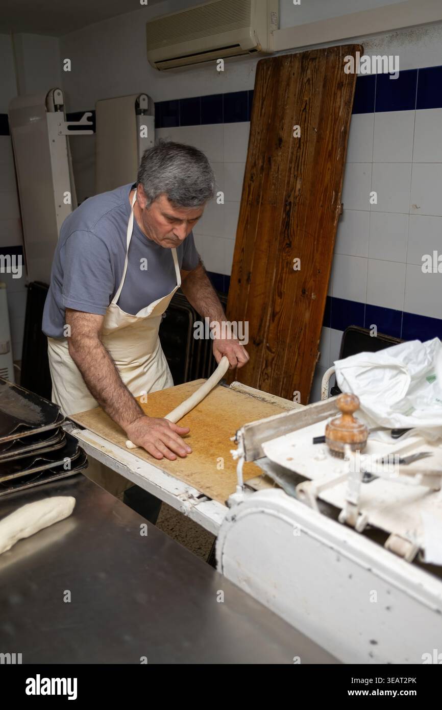 Mains de boulanger artisan façonnant la pâte dans la cuisine de boulangerie Banque D'Images