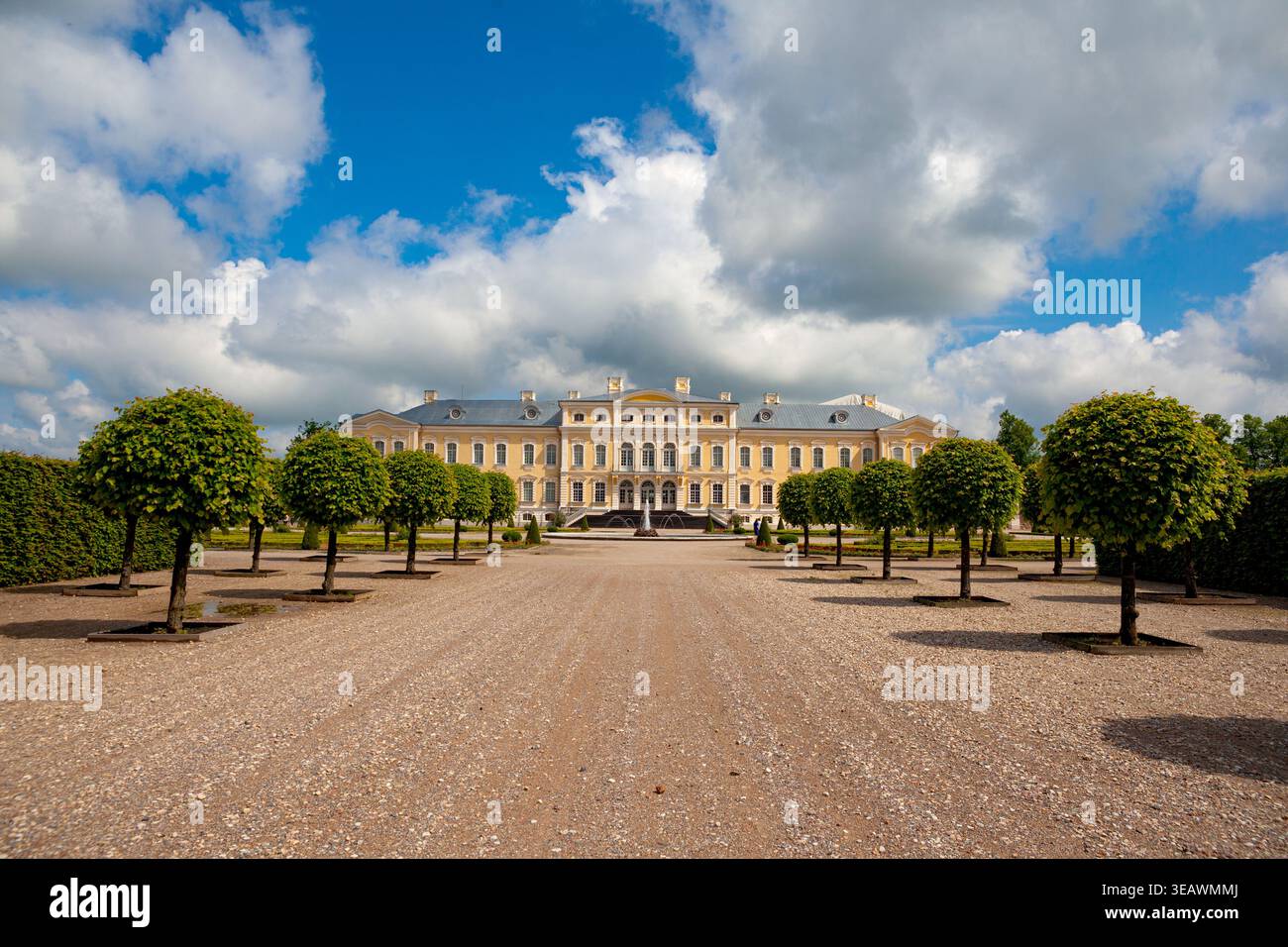 Vue panoramique sur le palais de Rundāle en Lettonie encadré par des rangées d'arbres parés symétriquement dans le jardin baroque formel. Le grand palais du XVIIIe siècle se dresse Banque D'Images