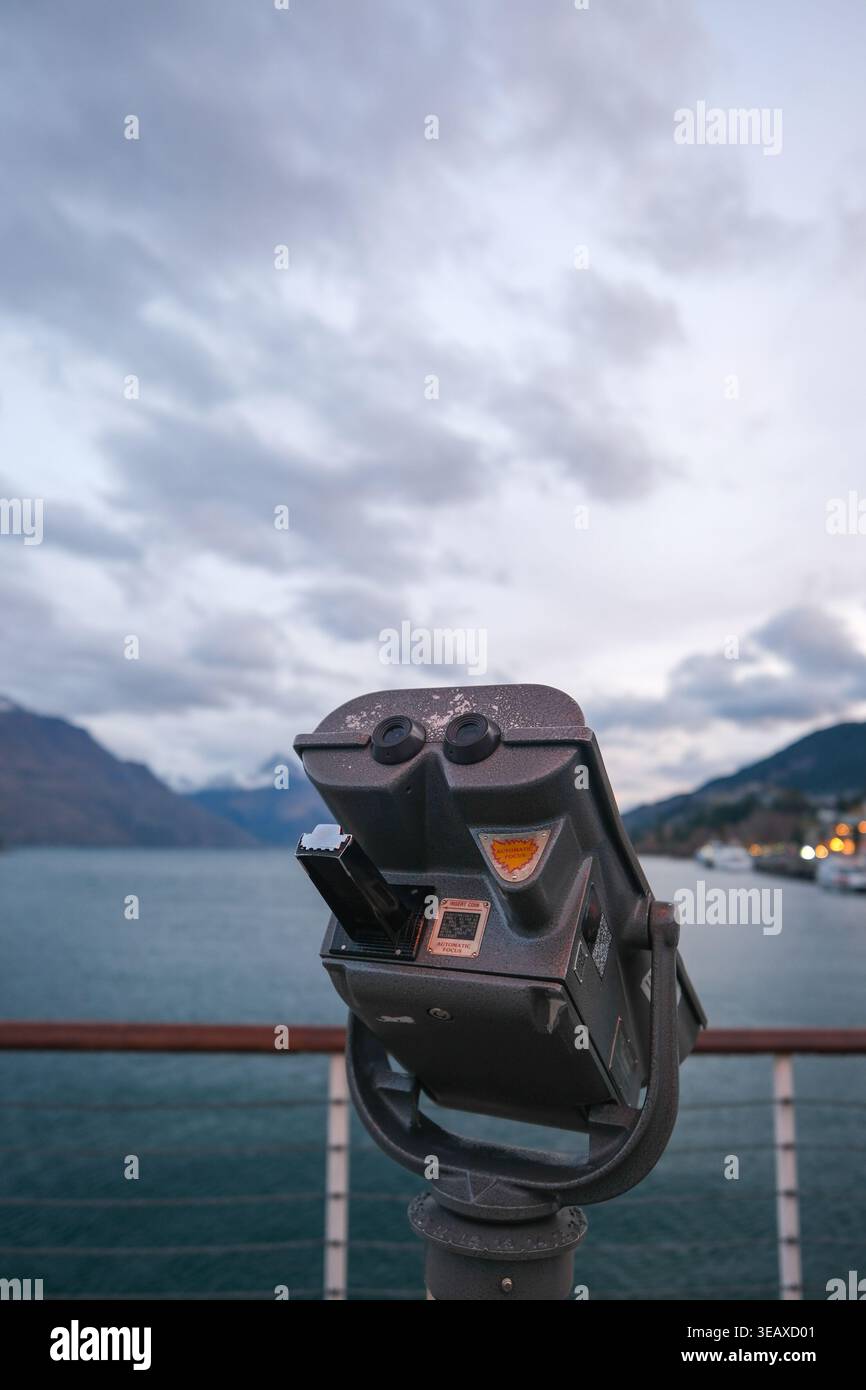 Visionneuse jumelle surplombant les montagnes enneigées et le lac Wakatipu depuis Queenstown main Town Pier. Banque D'Images