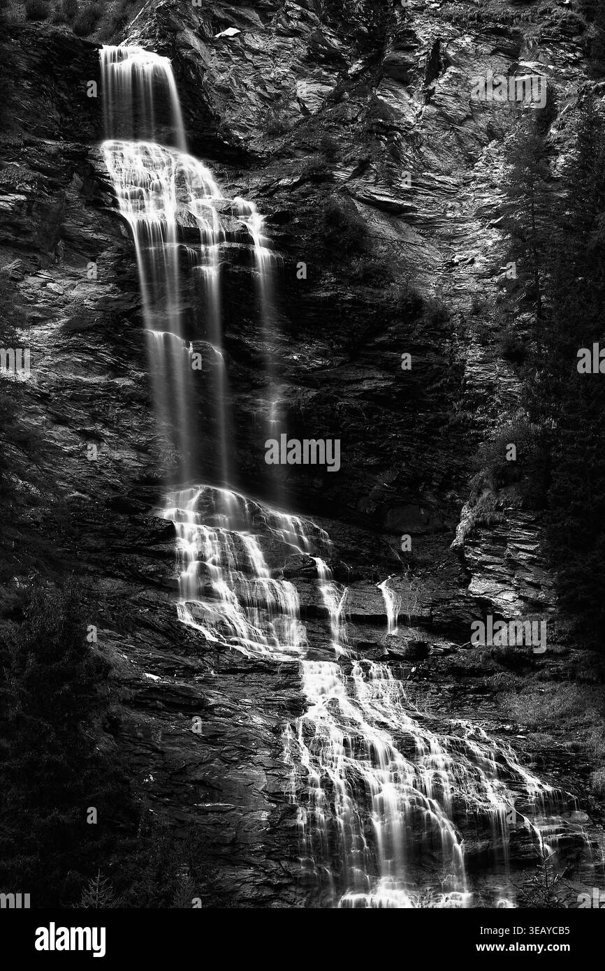 Noir et blanc longue exposition de la cascade de Borghetto descendant les falaises alpines accidentées en Lombardie, Italie Banque D'Images