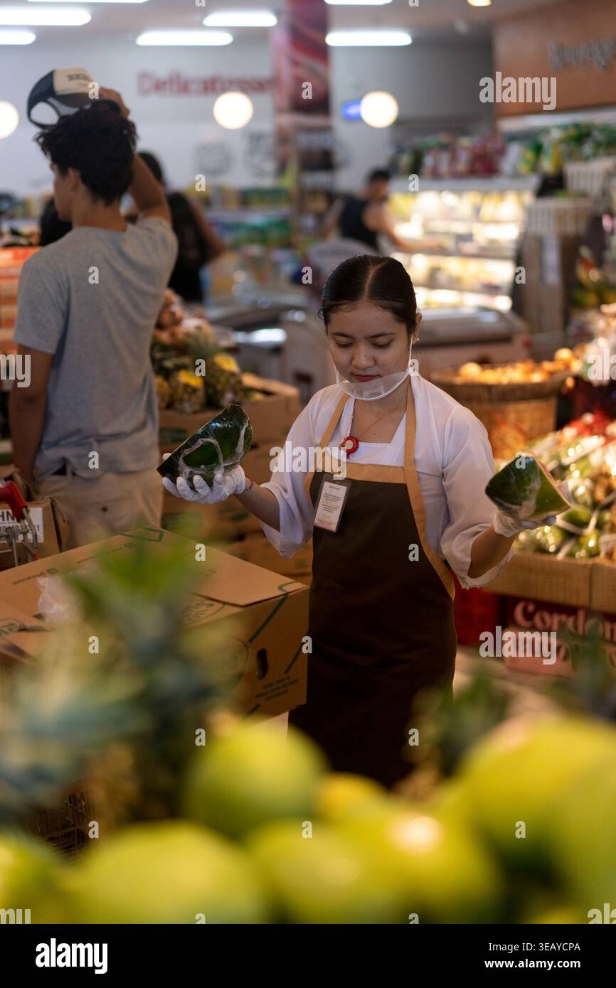 Travailleuse balinaise tenant la pastèque dans un supermarché, Bali Banque D'Images