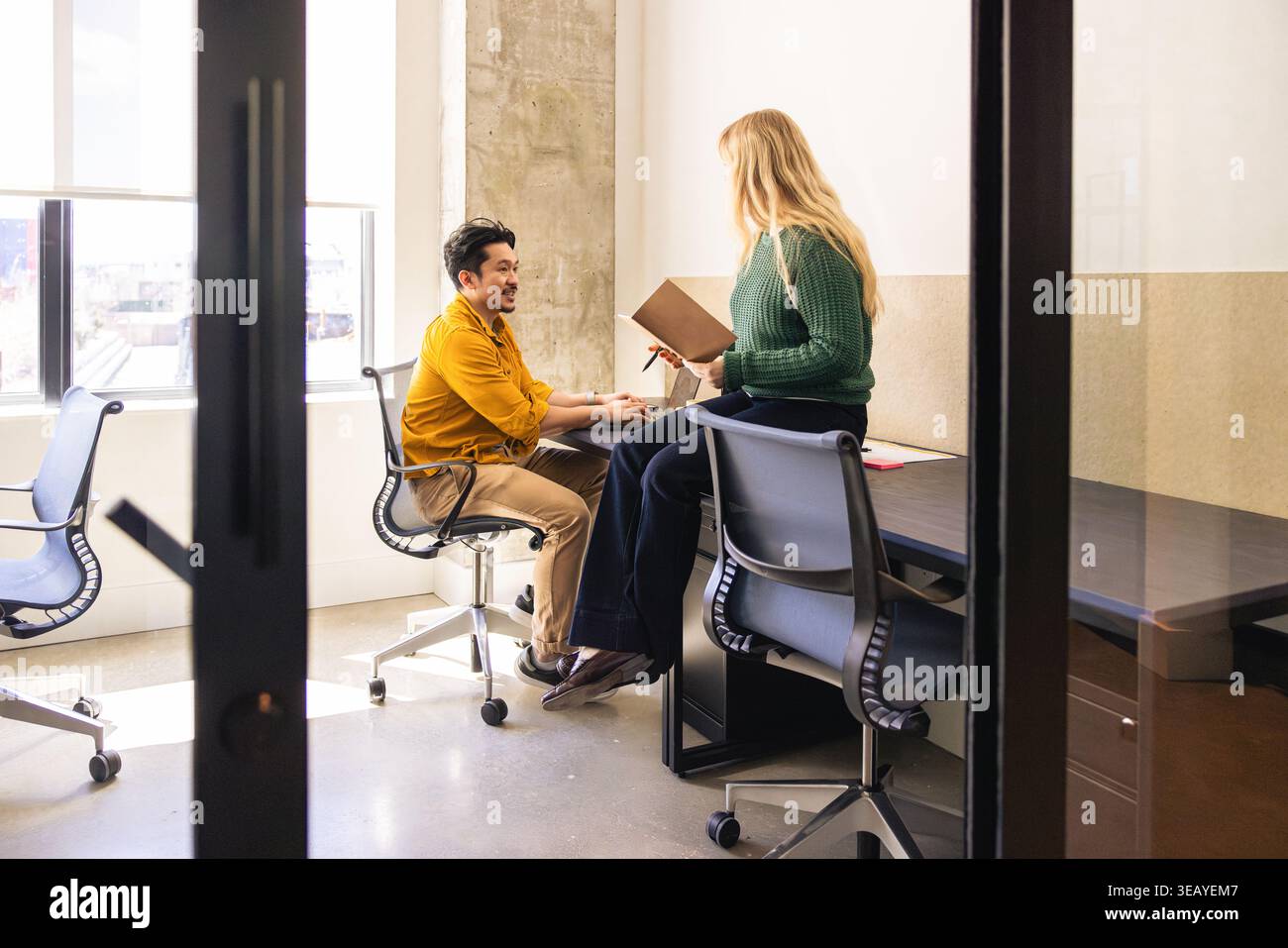 Jeunes collègues en discussion dans un espace de bureau moderne Banque D'Images