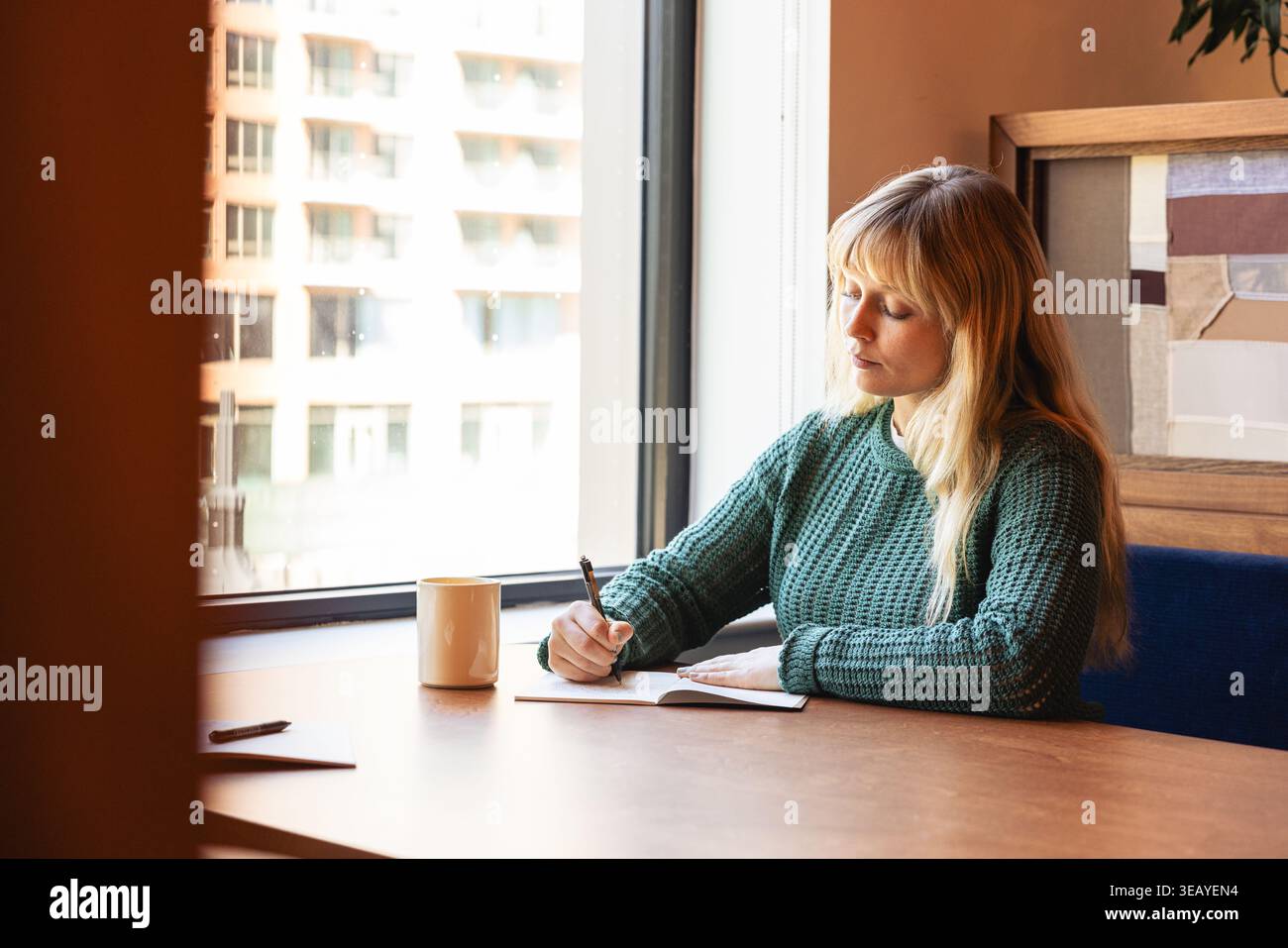 Femme caucasienne prenant des notes au bureau Banque D'Images