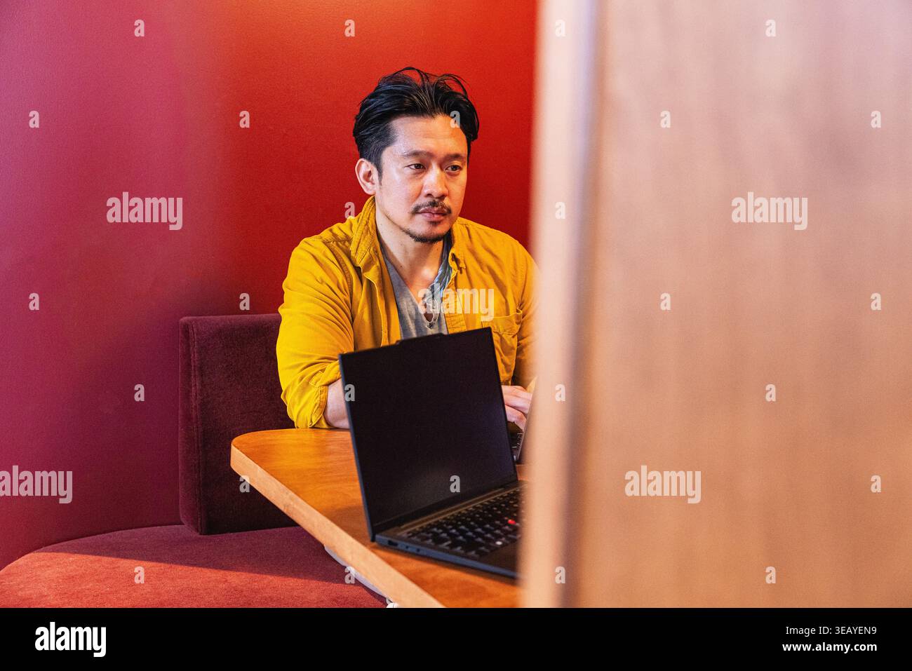 Homme asiatique professionnel assis à une réunion avec un ordinateur portable Banque D'Images