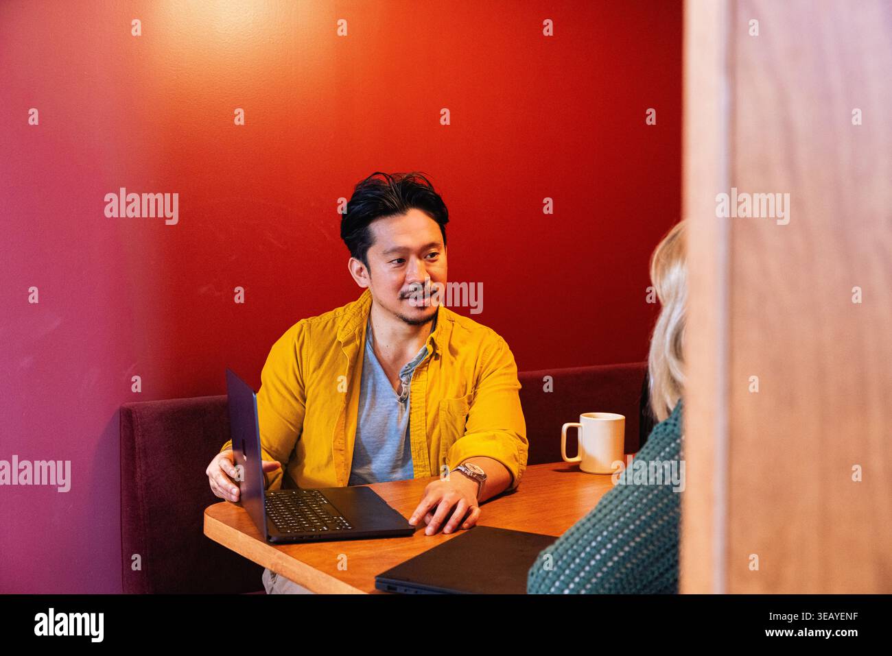 Homme d'affaires asiatique partageant sur son ordinateur portable au travail Banque D'Images