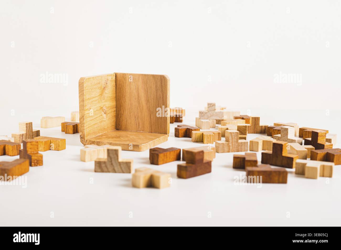 Puzzles en bois et boîte de collecte vide sur fond clair Banque D'Images