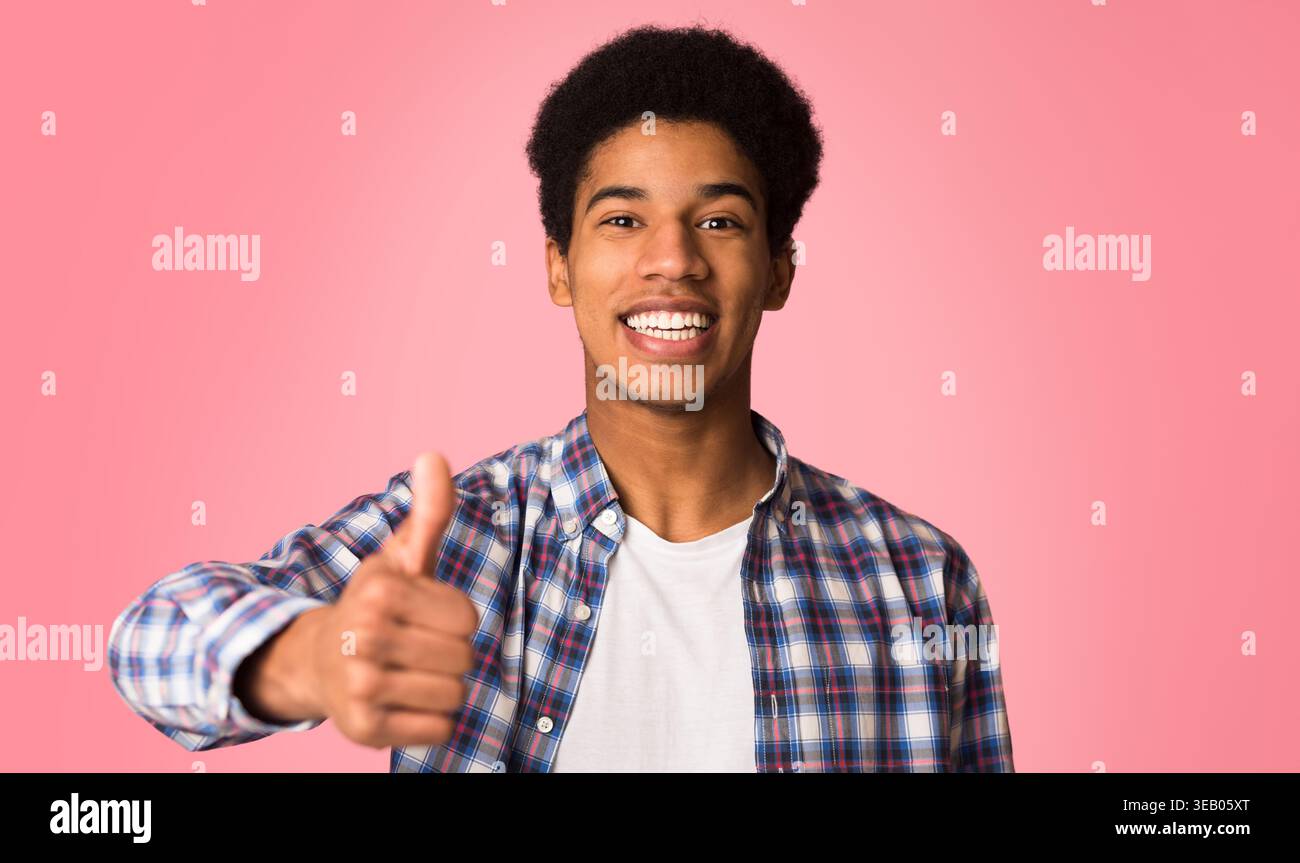 Vous recommander. Heureux guy showing thumb up and smiling Banque D'Images