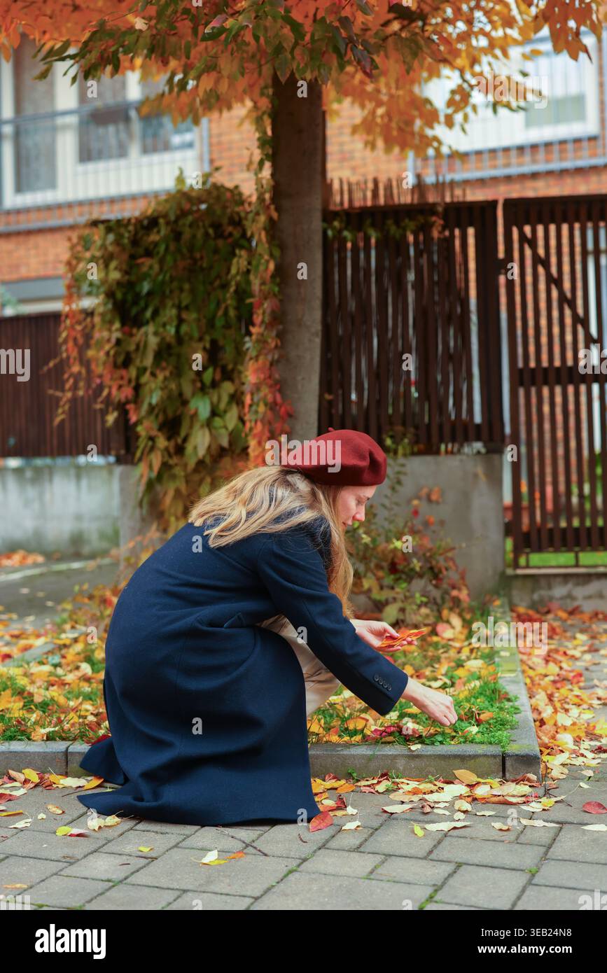 Femme avec fond de feuillage d'automne, humeur calme et couleurs saisonnières. Banque D'Images