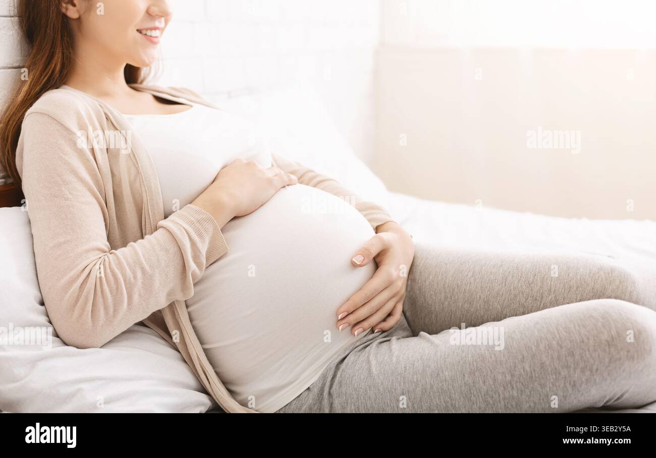 Future mère se relaxant à la maison tout en profitant de moments tranquilles de grossesse Banque D'Images
