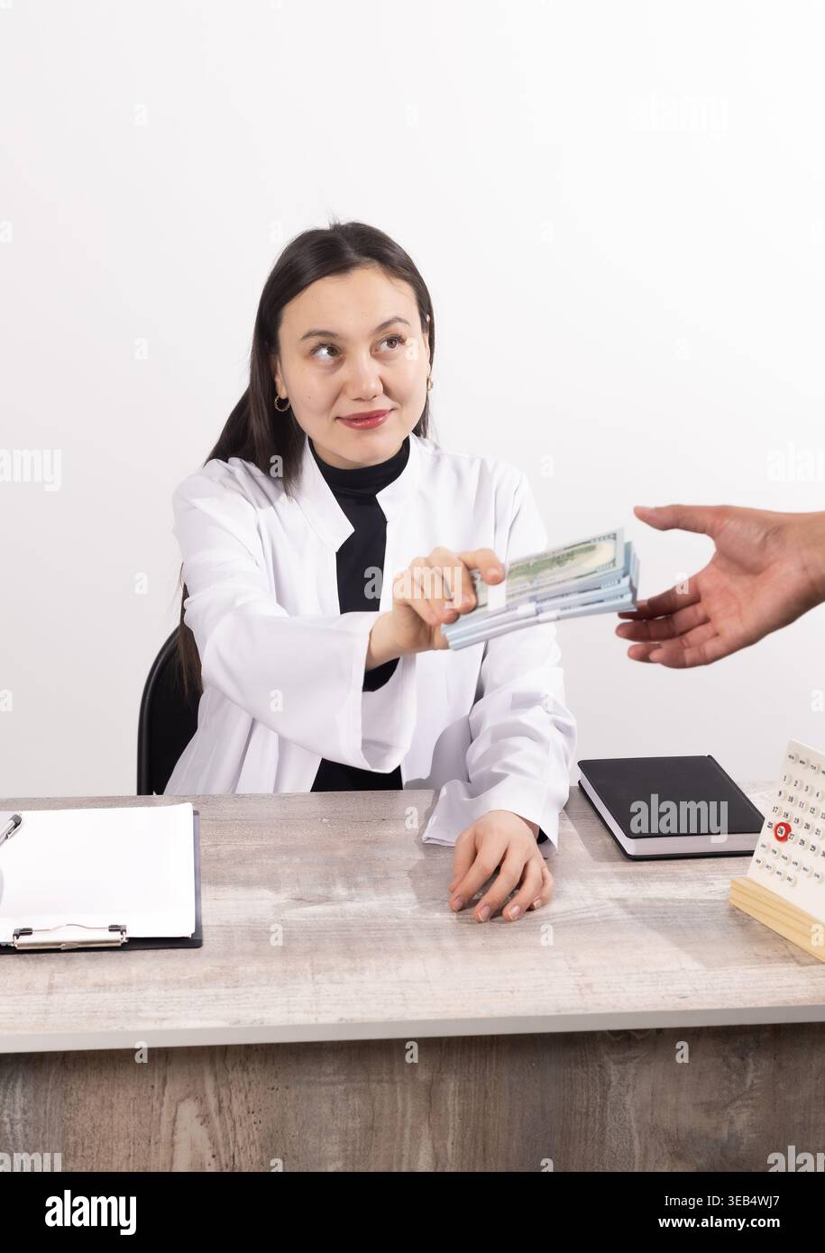 Homme d'affaires donnant de l'argent à une femme à un bureau Banque D'Images