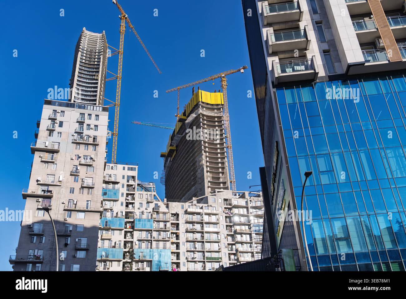 Batumi, géorgie 21 avril 2026 : batumi, géorgie développement urbain montrant des bâtiments résidentiels modernes avec balcons et grues de construction contre A. Banque D'Images