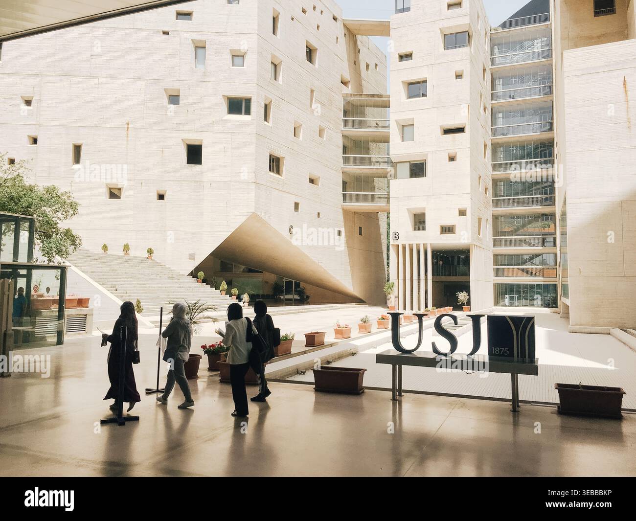Les étudiants traversent une cour intérieure d'un campus universitaire de l'Université Saint Josef francophone dans la capitale libanaise Beyrouth pendant une journée d'été ensoleillée. Banque D'Images