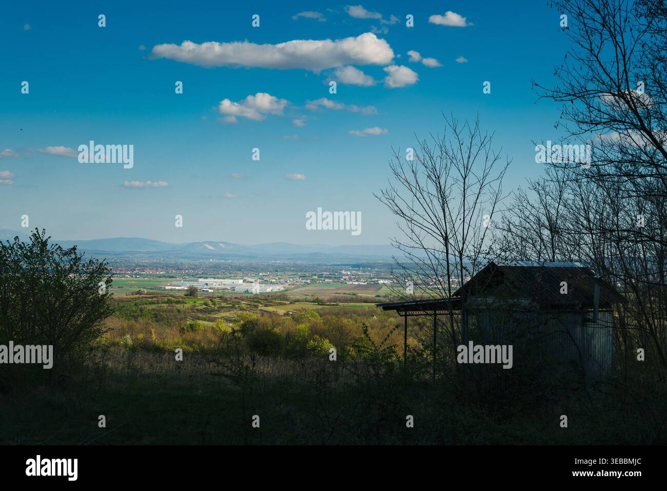 Paysage de vallée rurale surplombant Jagodina Serbie, vue sur la ville de campagne avec petite maison sous ciel bleu et nuages Banque D'Images