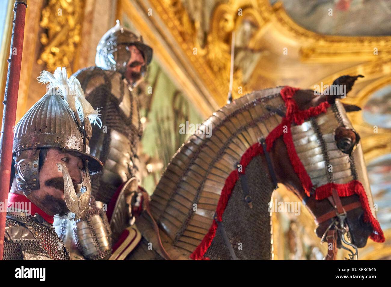 L'image représente une vitrine muséale élaborée mettant en scène deux personnages armés et un cheval caparaçonné, présentant des tenues militaires historiques dans un Banque D'Images