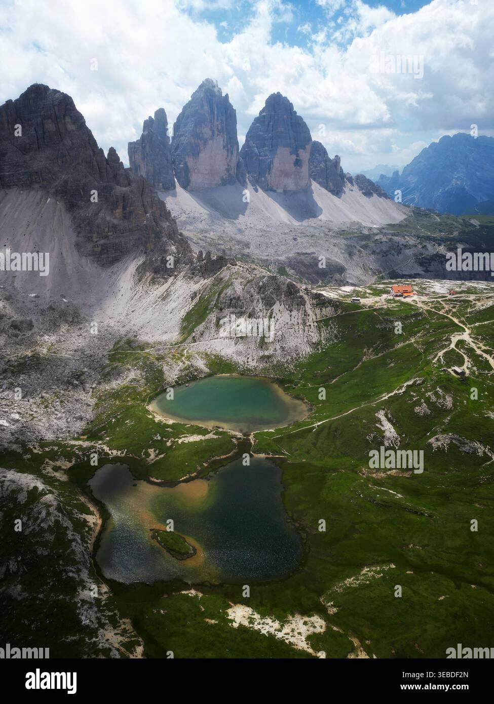 Vue aérienne des pics Tre Cime di Lavaredo surplombant les lacs alpins et les prairies verdoyantes dans les Dolomites, Italie. Banque D'Images