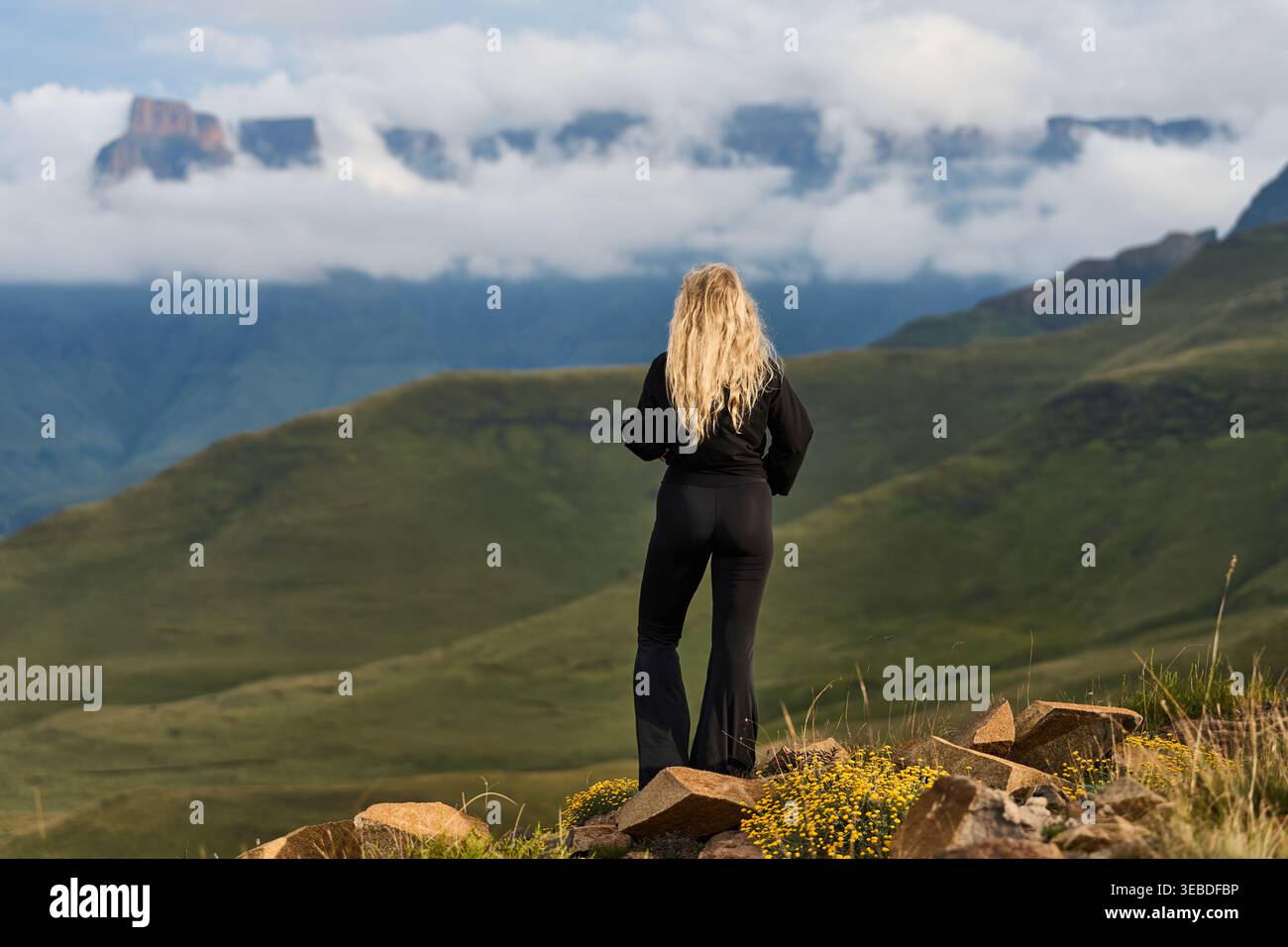 Photographe de voyage capturant un moment solitaire au milieu des collines brumeuses et des formations nuageuses spectaculaires Banque D'Images