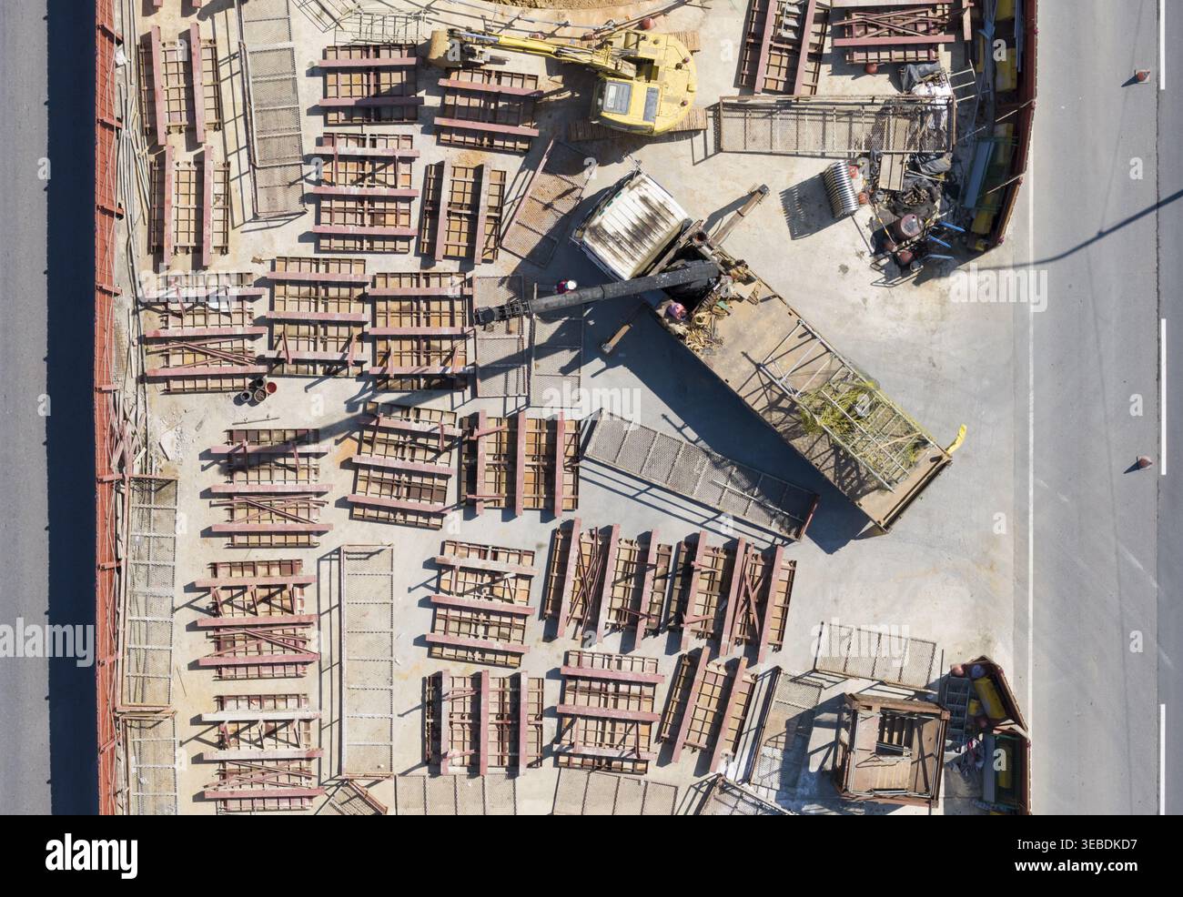 Vue aérienne du chantier de construction d'autoroute surélevé avec des machines lourdes, une pelle jaune, des piles de matériaux de construction et des travailleurs à Taiwan. Banque D'Images