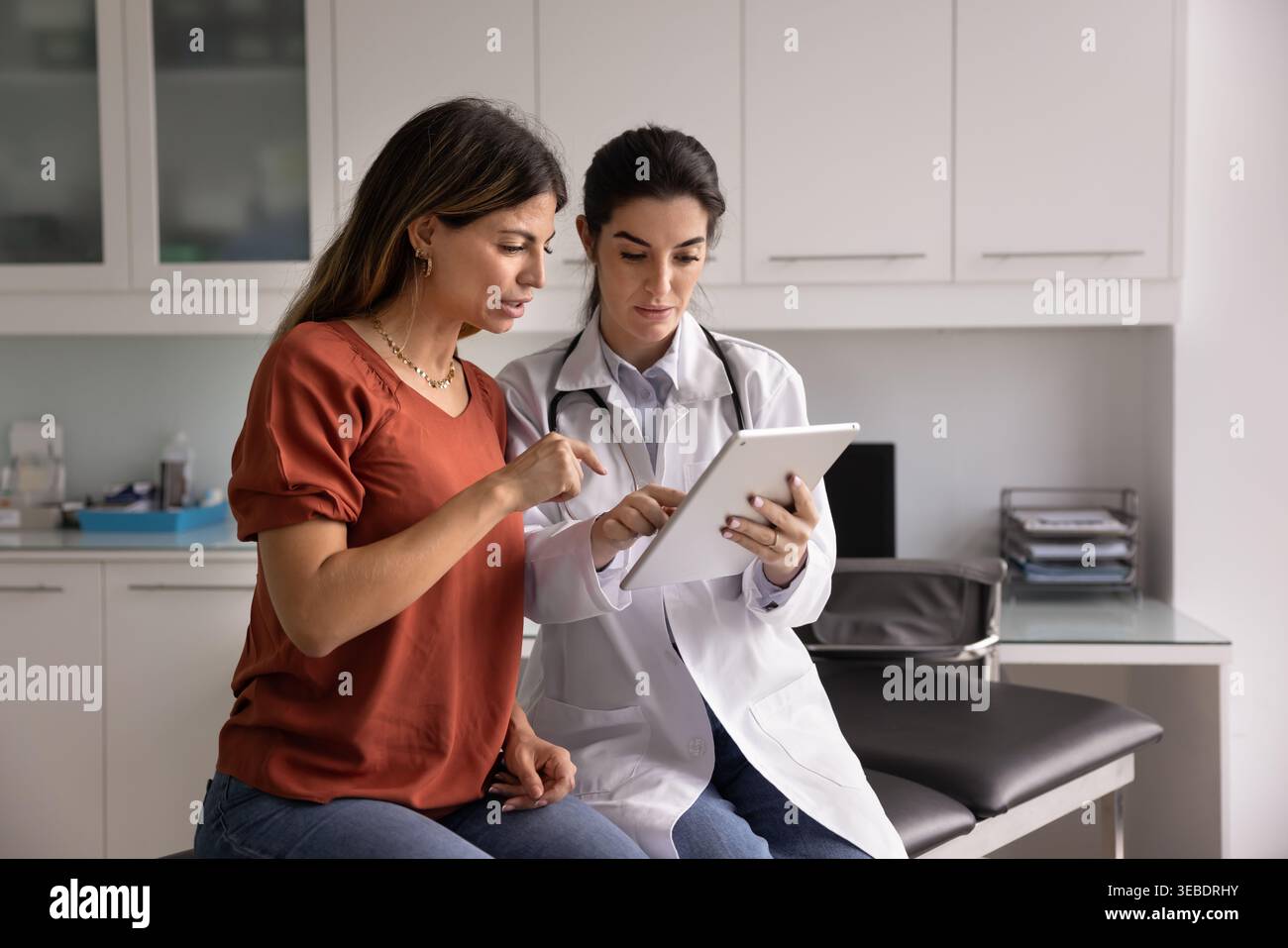 Médecin féminin montrer des informations médicales au patient sur comprimé Banque D'Images