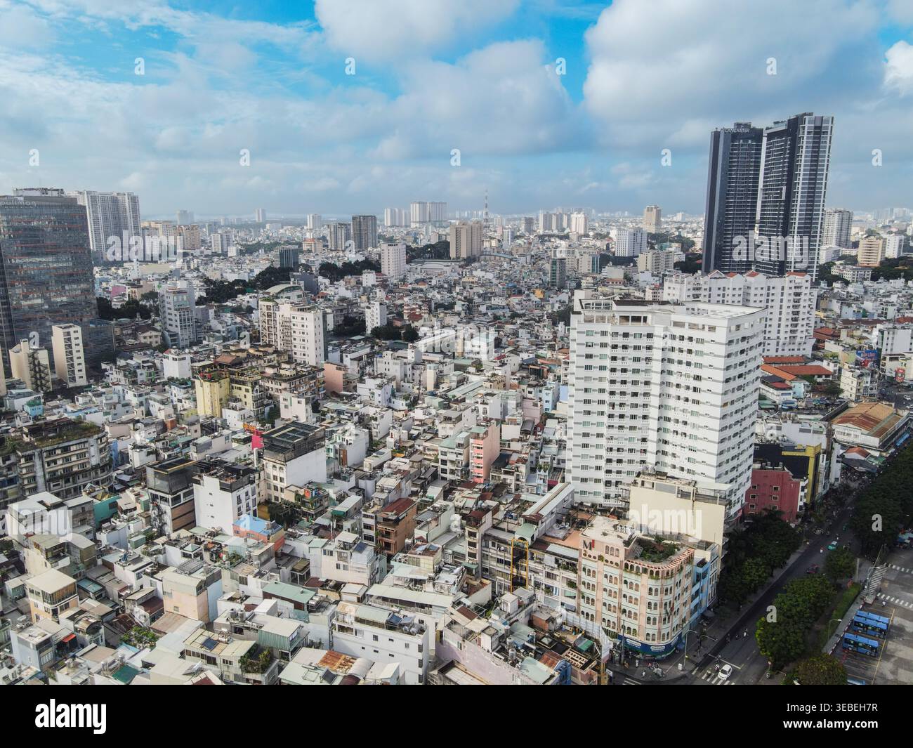 Vue aérienne de l'horizon urbain dense avec un mélange de gratte-ciel modernes et de bâtiments résidentiels traditionnels sous un ciel bleu avec des nuages blancs à Ho Banque D'Images