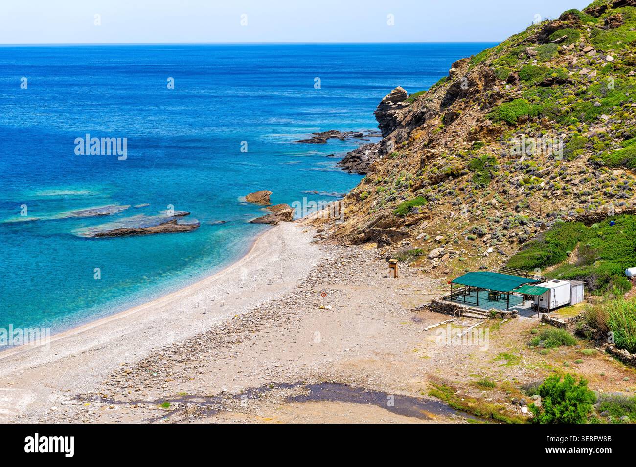 Plage d'Aris au village de Karavostamo sur l'île d'Ikaria, Grèce avec vue sur la nature du paysage par un bâtiment vide de restaurant de café Banque D'Images