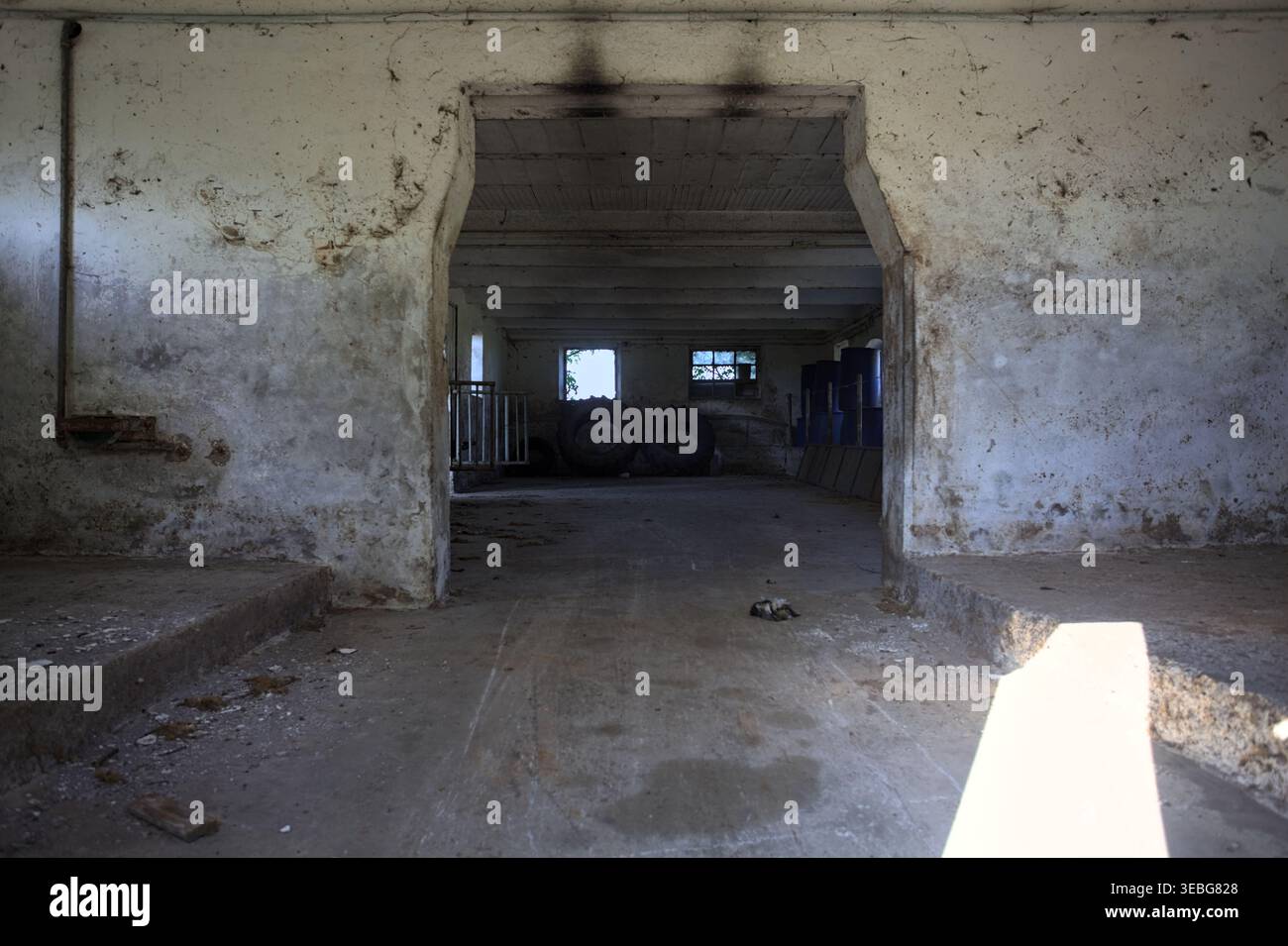 Grange vide dans un manoir abandonné avec un rayon de soleil entrant dans la chambre, dans la campagne italienne Banque D'Images