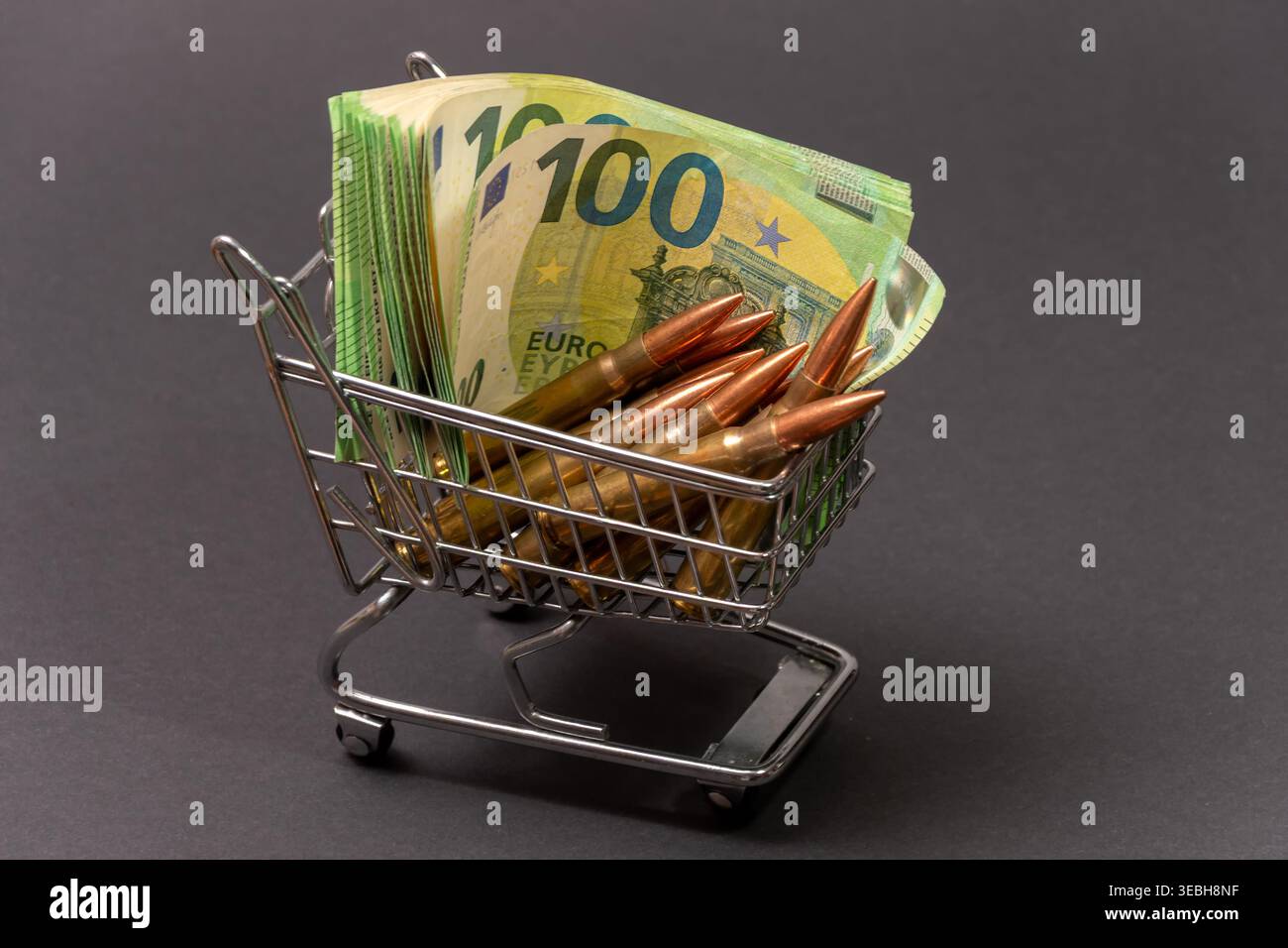 Chariot avec balles et billets en euros sur fond sombre. Banque D'Images