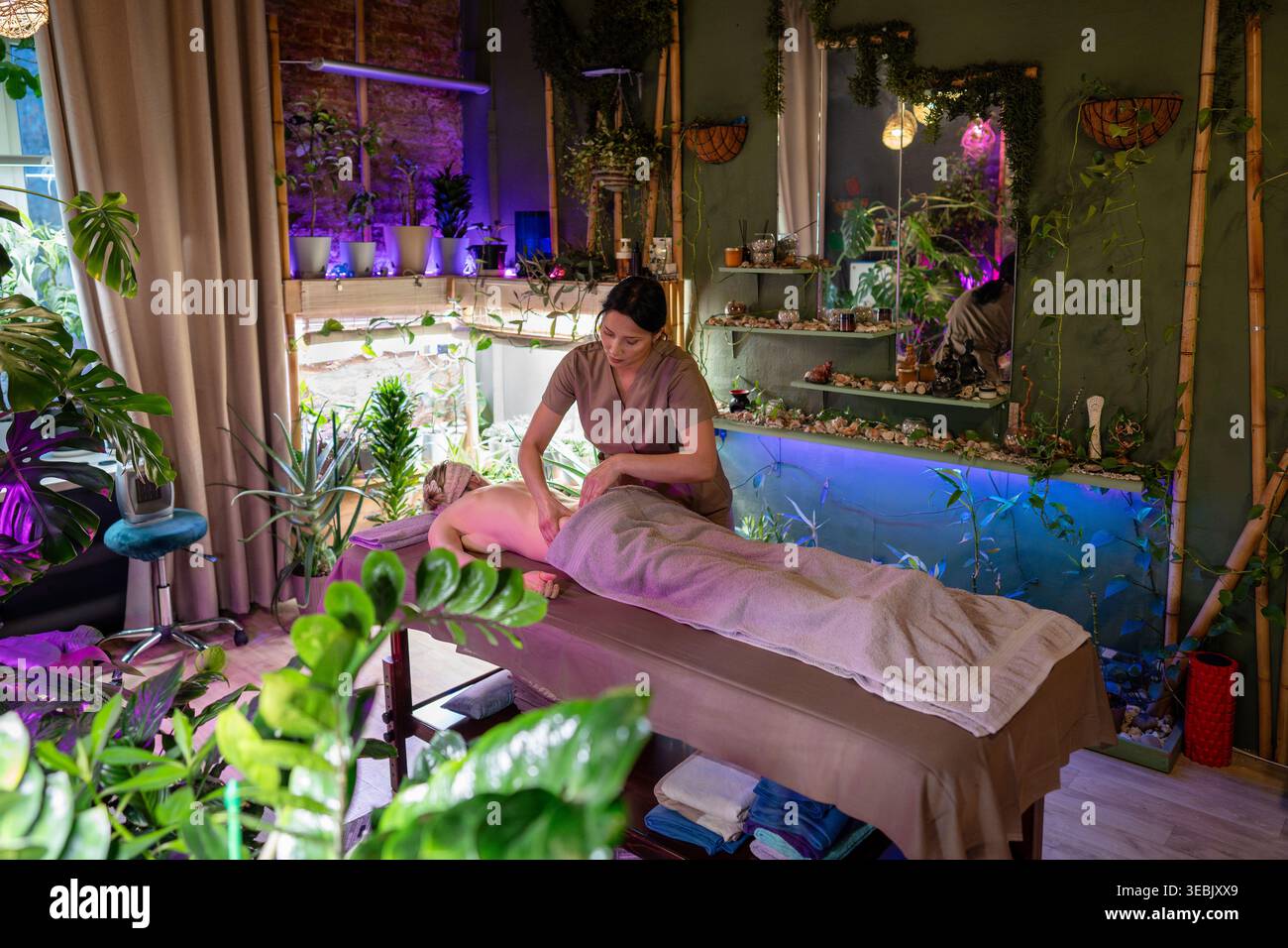 Soins corporels et rituels de beauté, masseuse professionnelle offrant un massage relaxant pour la cliente féminine. Banque D'Images