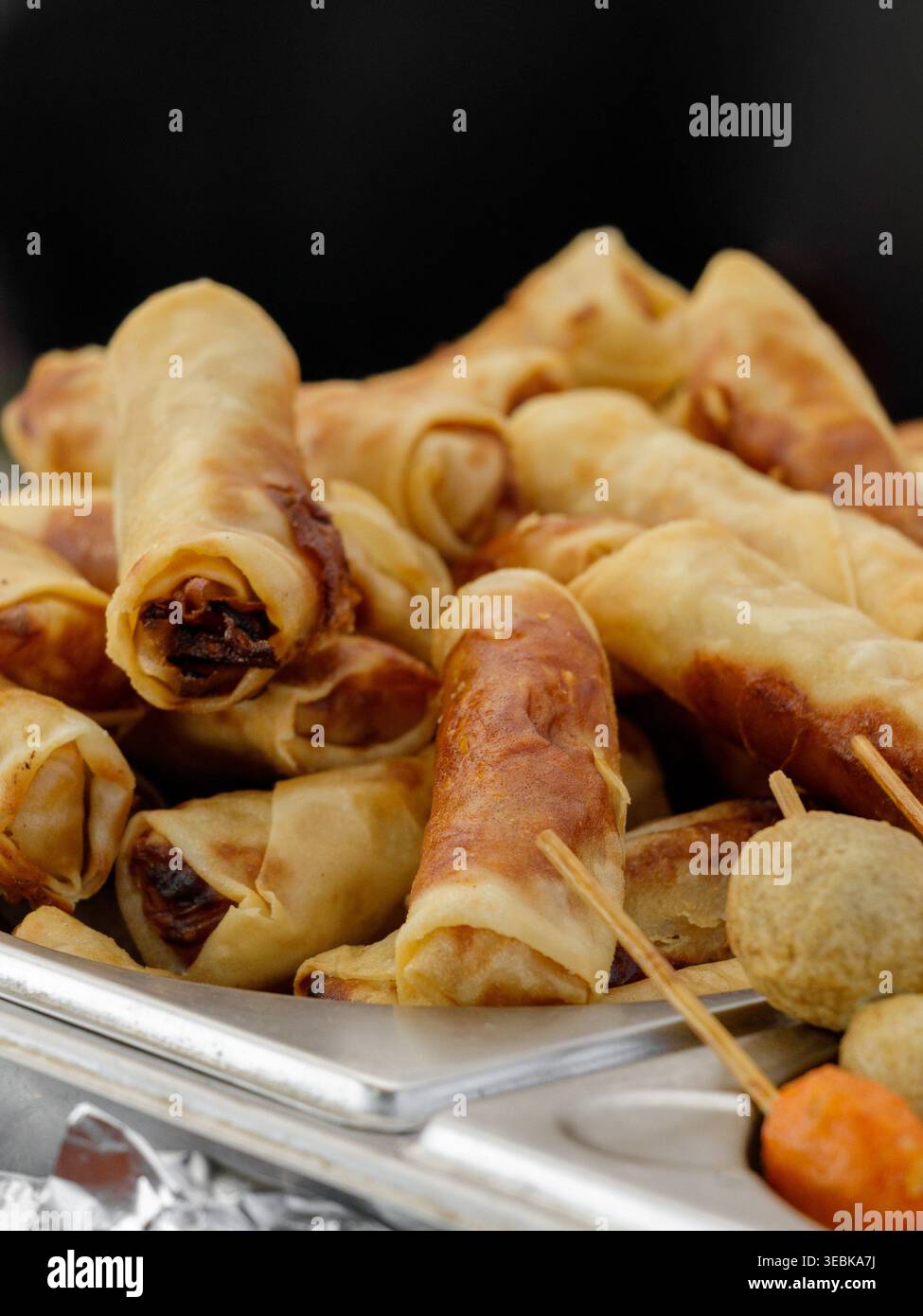 Rouleaux de printemps dorés avec garniture salée. Rouleaux de printemps croustillants empilés sur un plateau prêt à servir Banque D'Images
