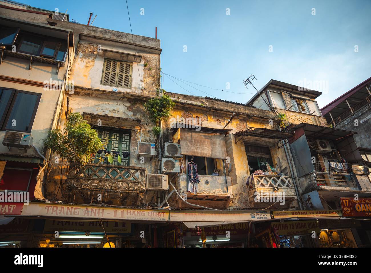Hà Nội, Vietnam - 07 octobre 2024 : vue sur les bâtiments de l'époque coloniale altérés avec des façades écaillées, des balcons complexes et des boutiques animées au niveau de la rue Banque D'Images