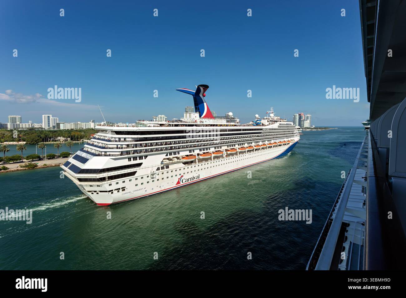 Miami, États-Unis - 16 mars 2026 : vue d'un majestueux bateau de croisière Carnival naviguant dans les eaux turquoises étincelantes de Port Miami sous un bleu vif Banque D'Images