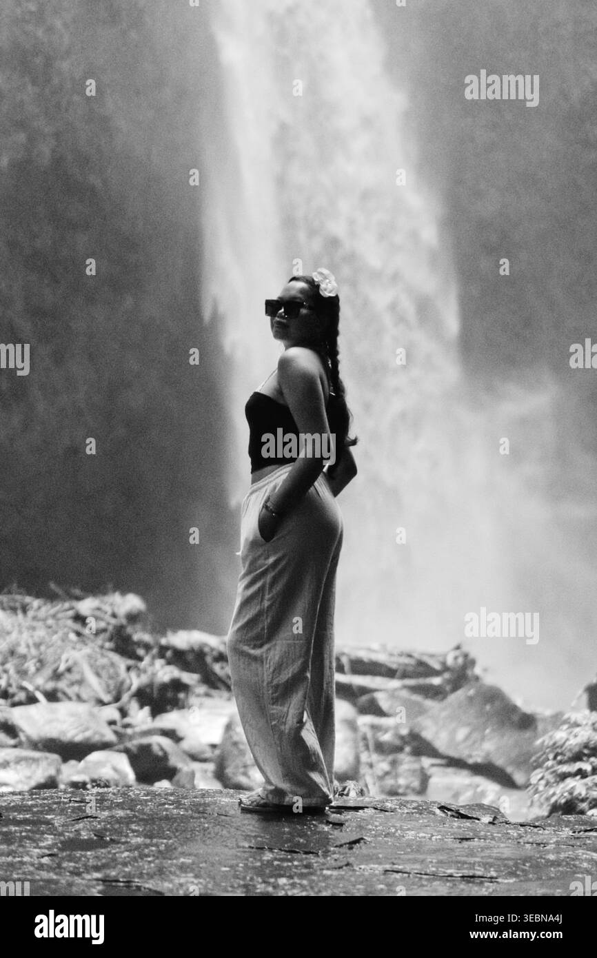 Femme élégante noire et blanche posant à Nungnung Waterfall, Bali Banque D'Images