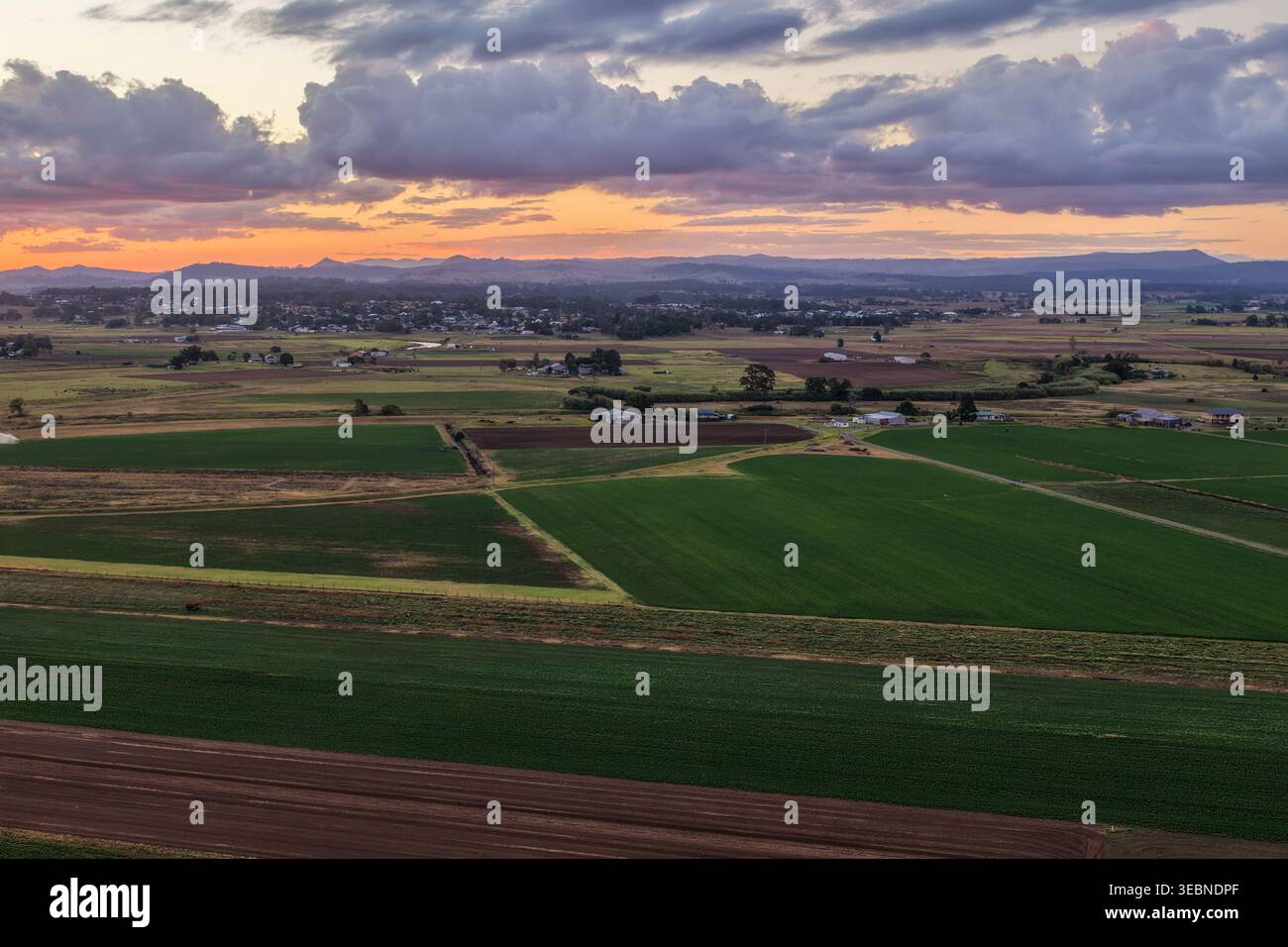 Vue aérienne du coucher de soleil coloré sur la rivière Morpeth et les terres agricoles environnantes en Nouvelle-Galles du Sud, Australie. Paysage rural pittoresque montrant un ciel vibrant Banque D'Images
