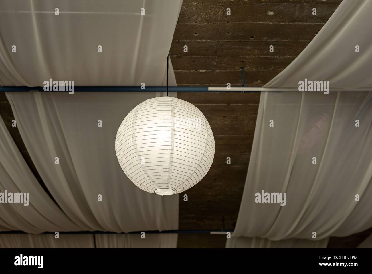 Une lanterne est suspendue au plafond au-dessus. Le tissu se drape le long du plafond, ajoutant une touche décorative au lieu. Cette configuration crée une sp. Invitante Banque D'Images