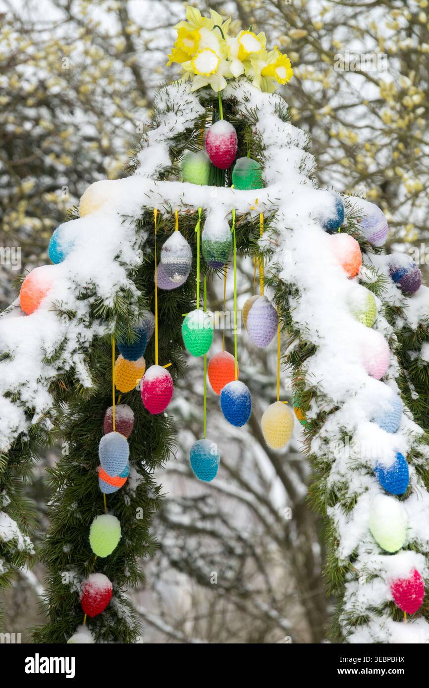 Couronne traditionnelle de puits de Pâques saxonne avec des œufs colorés dans la neige dans un jardin Banque D'Images