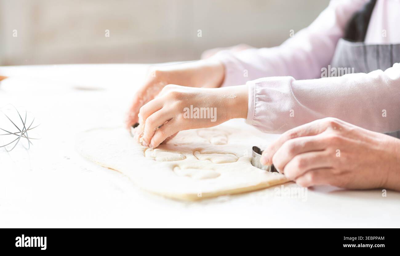 Cuisson des cookies dans une cuisine lumineuse avec les mains façonnant la pâte Banque D'Images