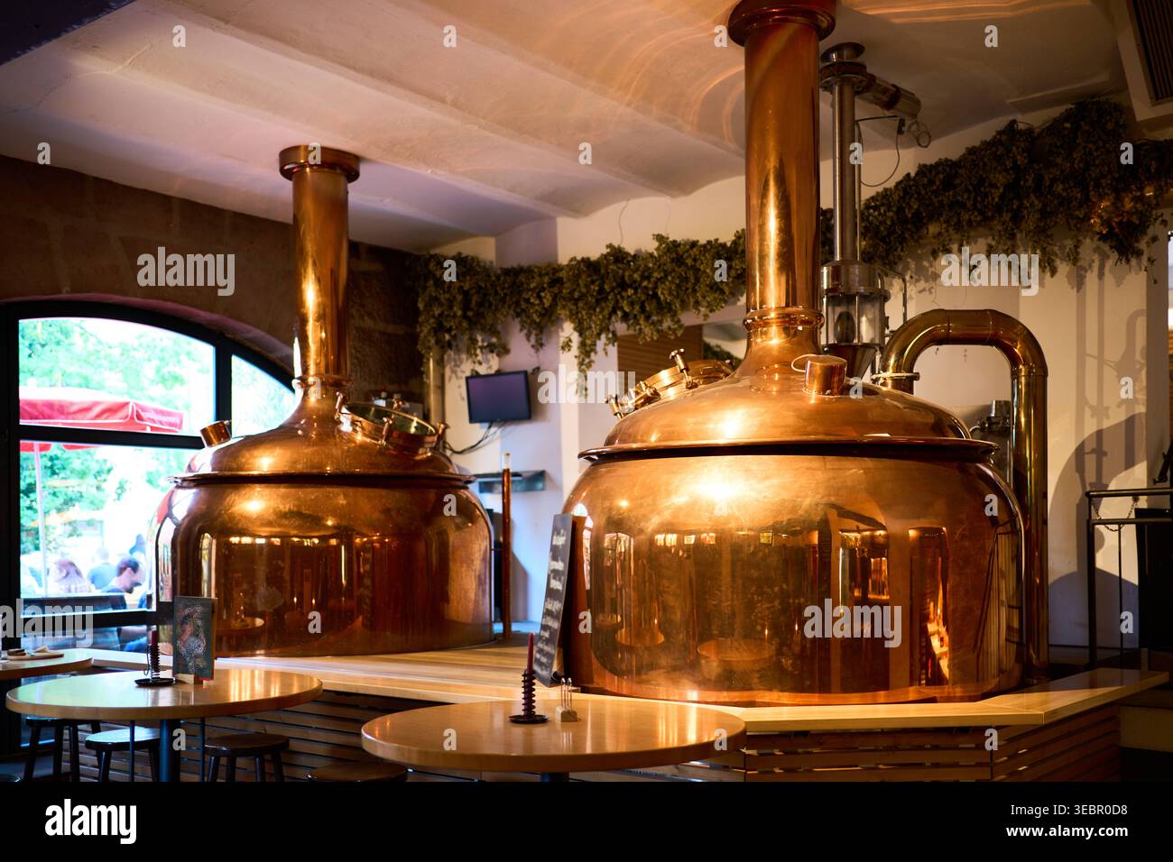 Intérieur d'une brasserie allemande traditionnelle avec de grandes bouilloires en cuivre poli. Installation de production de bière authentique et scène de brasserie artisanale. Banque D'Images