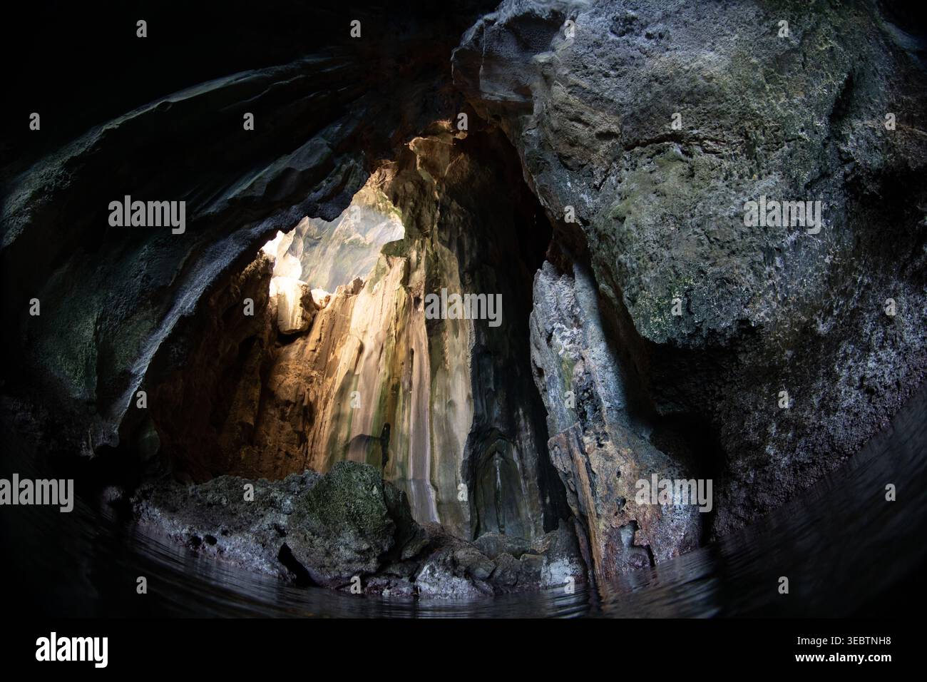 La lumière du soleil tombe à travers une lucarne dans la grotte de la cathédrale située sur l'île de Pinisil, aux Philippines. Cette merveille géologique est une attraction touristique célèbre. Banque D'Images
