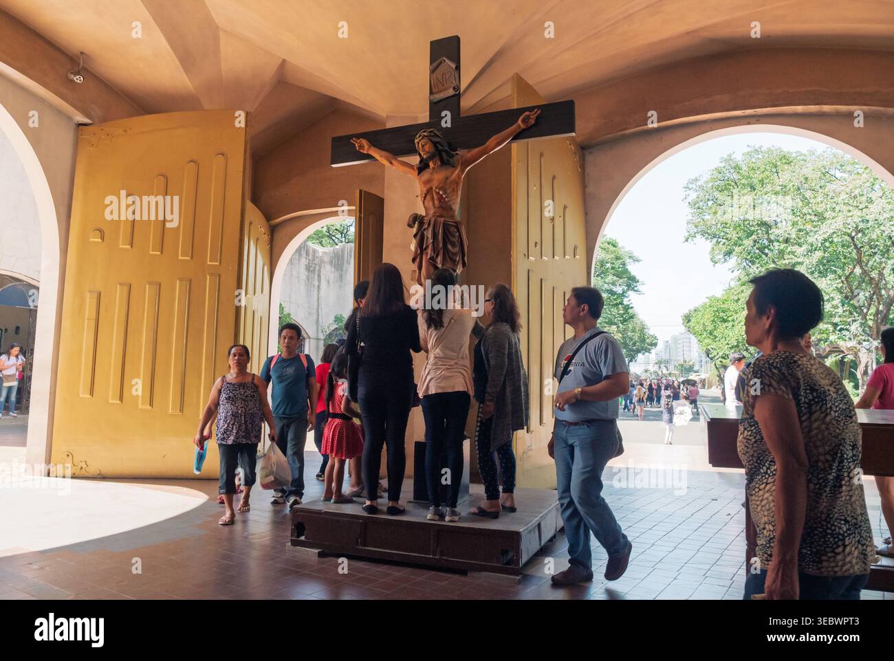 Manille, Philippines - 26 novembre 2018 : les dévots philippins se rassemblent autour d'une statue de crucifix pour la prière et la vénération dans une cour historique de l'église Banque D'Images