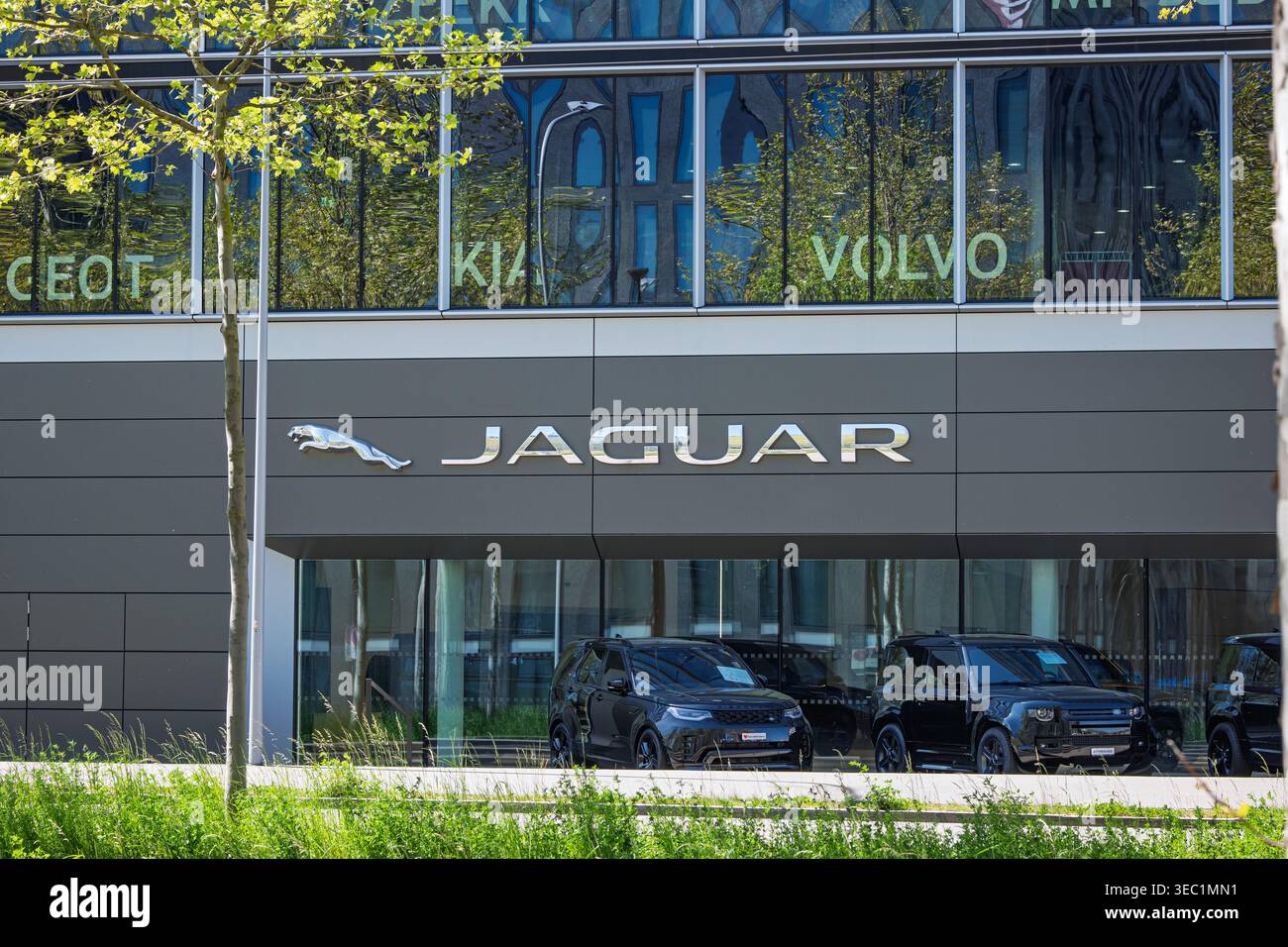 Zurich, Suisse, 23 avril 2026. Vue extérieure mettant en valeur le grand logo Jaguar Cat et la signalétique de la marque sur la façade moderne d'une concession à Oerlikon, Banque D'Images