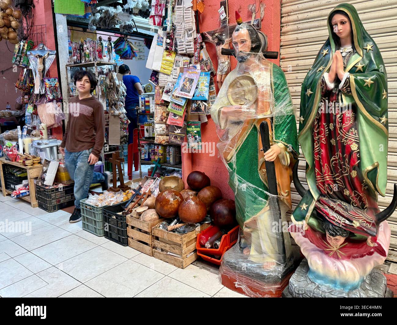 Statues religieuses et objets de dévotion exposés devant un magasin du marché Lucas de Gálvez, Mérida, Yucatán, Mexique. - Image de stock capturée avec un smartphone