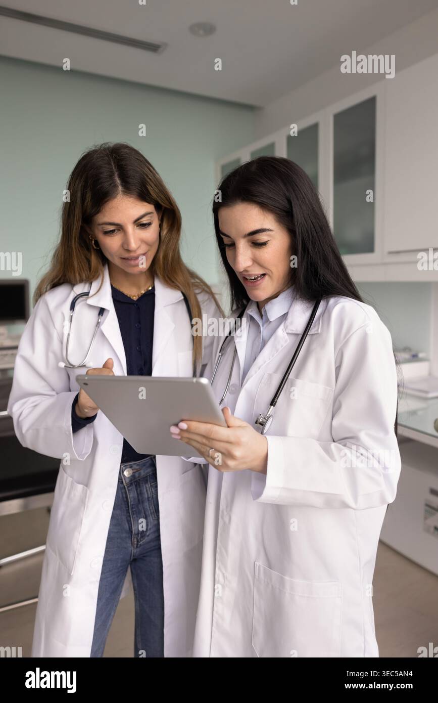 Médecin féminin guide collègue, travaillant, préparant le rapport médical ensemble Banque D'Images