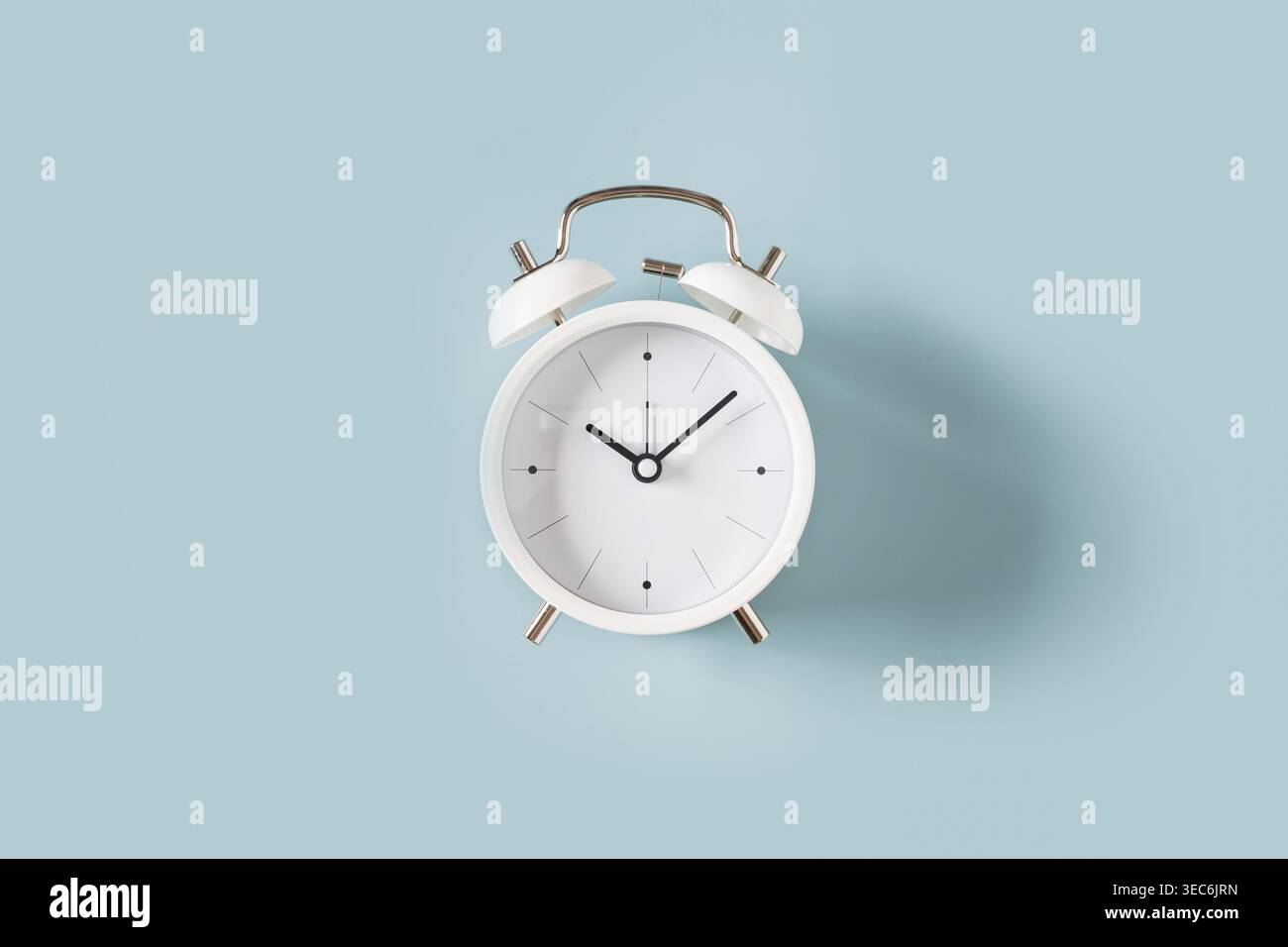 Réveil blanc sur fond bleu, concept minimal de gestion du temps, idée de calendrier et de productivité, espace de copie Banque D'Images