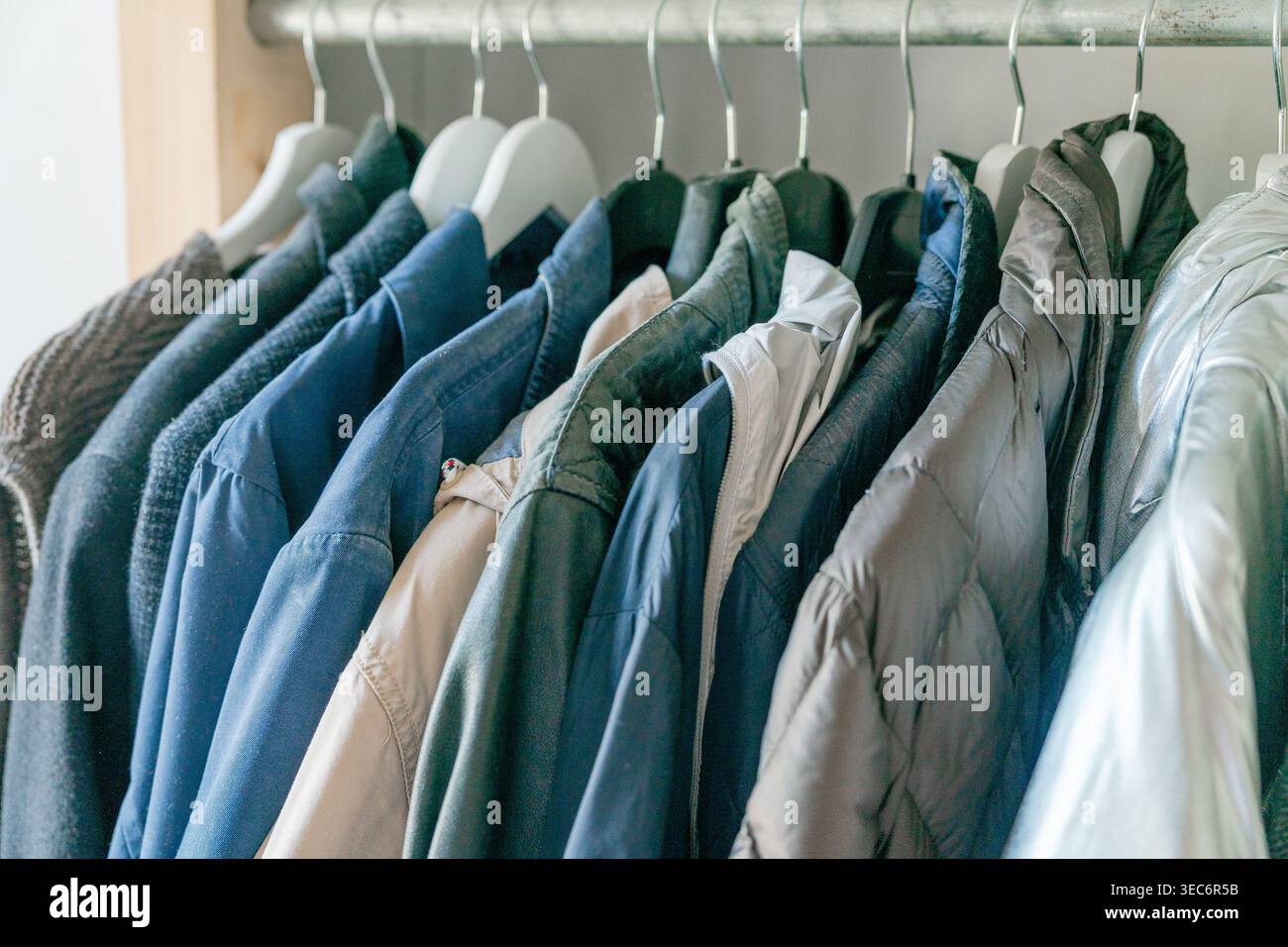 Vêtements pour hommes soigneusement disposés sur des cintres. Intérieur de garde-robe propre et minimal. Banque D'Images