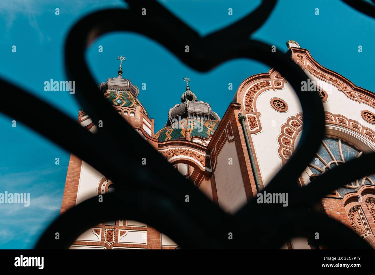 Subotica Synagogue vue à travers une clôture décorative en fer à Subotica, Serbie. Vue artistique du monument historique Art Nouveau avec des détails ornés. Banque D'Images