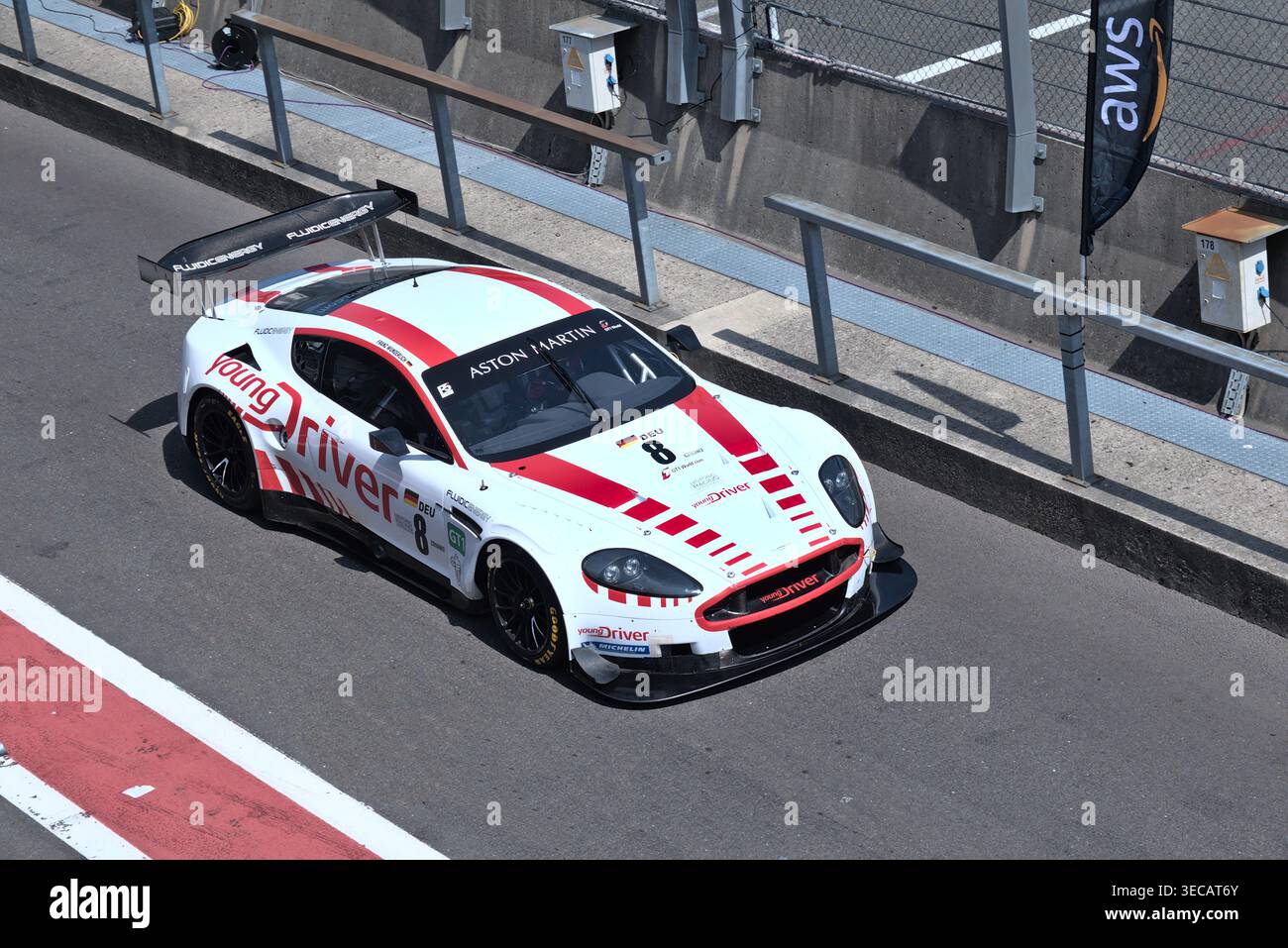 L’Aston Martin DBR9 #8 de Frank Wunderlich longe la voie des stands devant les garages de l’équipe lors de l’événement SRO GT 30th Anniversary à Spa. Banque D'Images