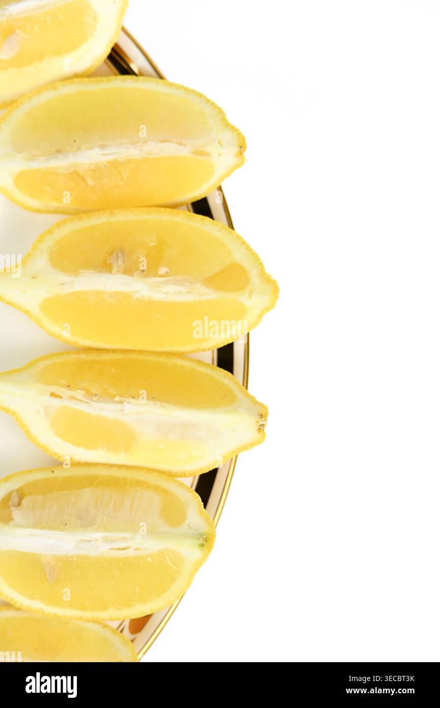 Tranches mûres de fruits de citron jaune sur une assiette fantaisie avec espace de copie Banque D'Images